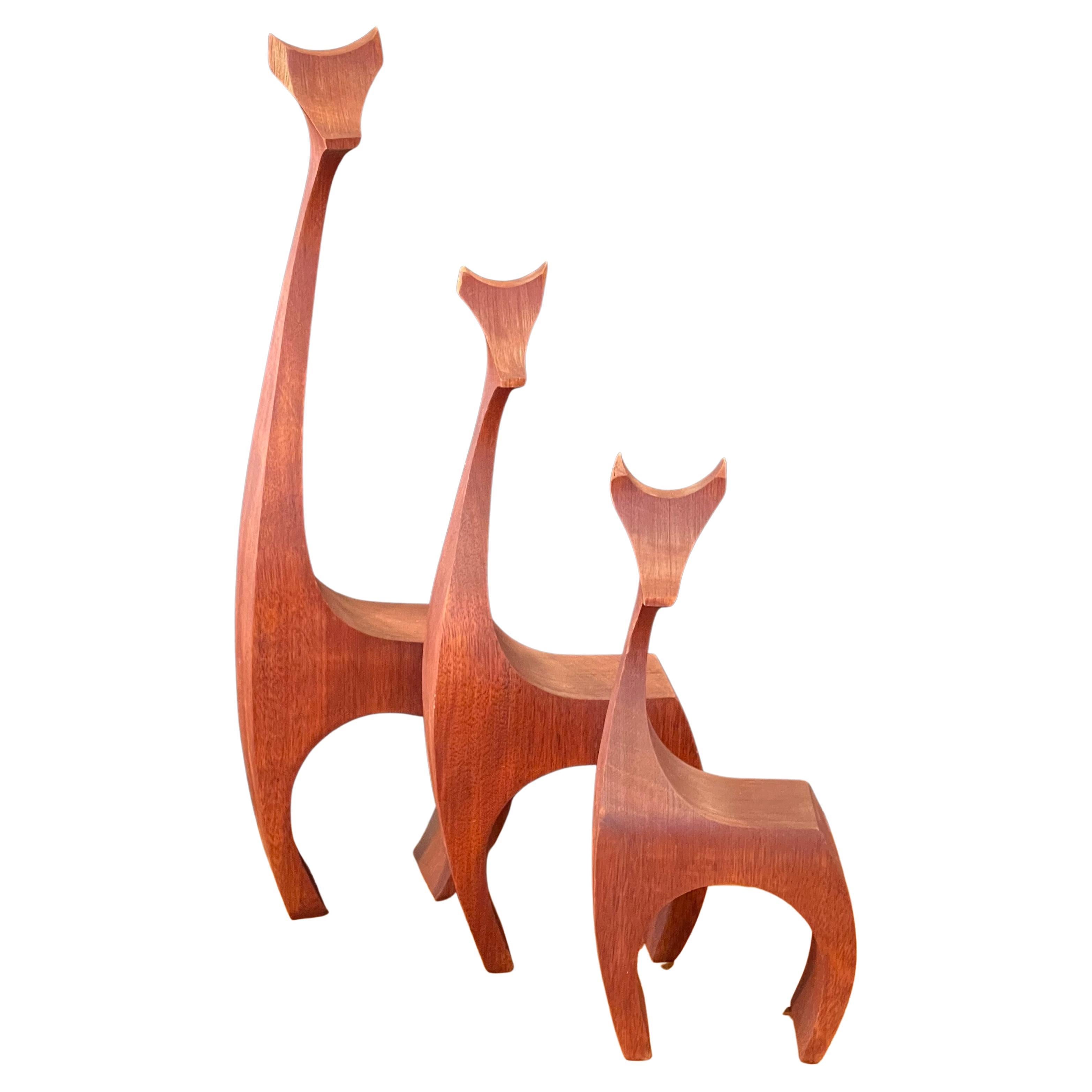 Un ensemble super cool de trois sculptures de girafes modernistes par Del Zotto Studios de Denver, CO, vers les années 1980. Les pièces sont sculptées à la main dans ce que je crois être du bois de teck et mesurent : 4,5 