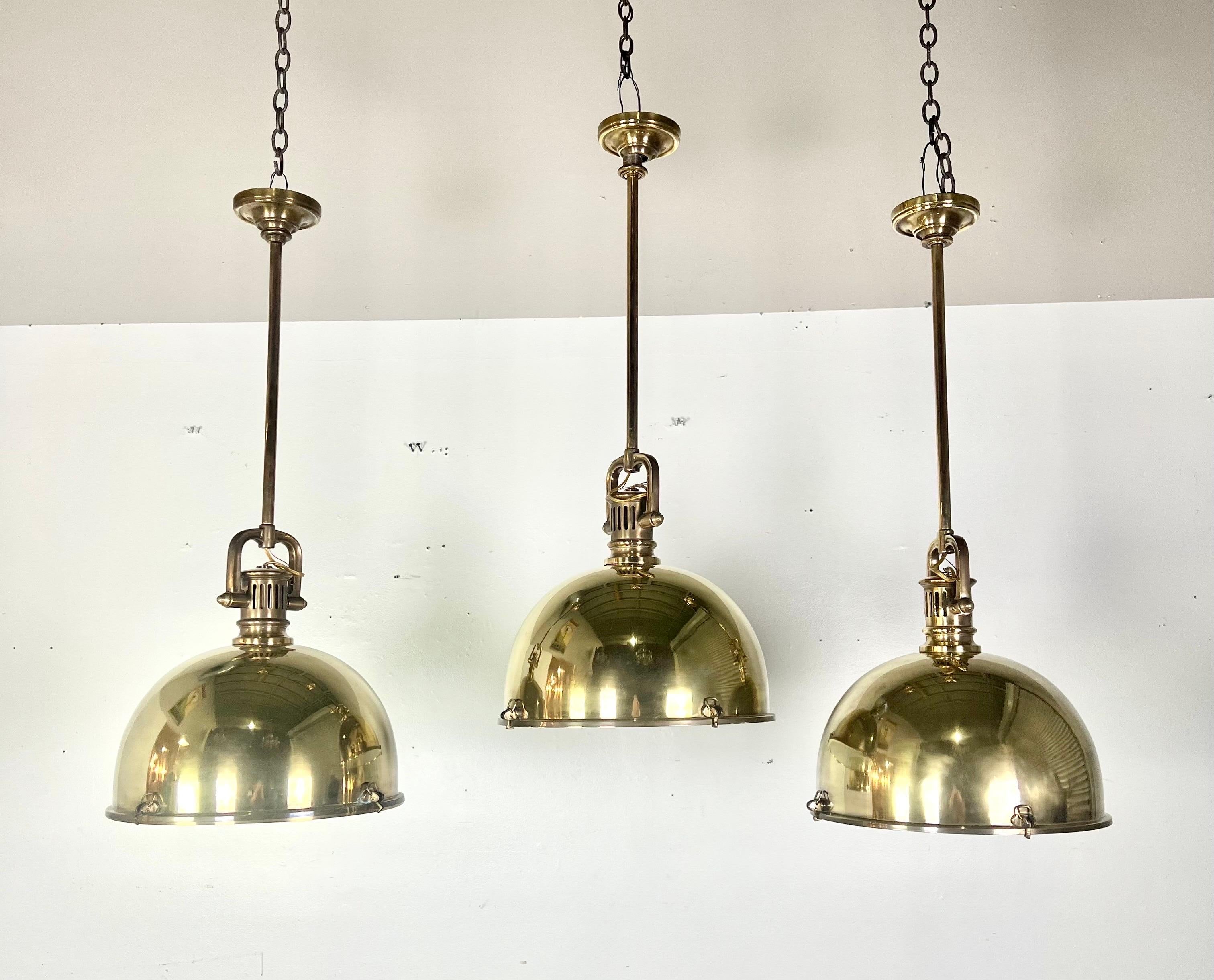A set of three modern brass dome-shaped light pendants that are both sleek and stylish.  The use of brass adds a touch of sophistication, and the dome shape often provides a contemporary aesthetic.  They are wired and ready to install.