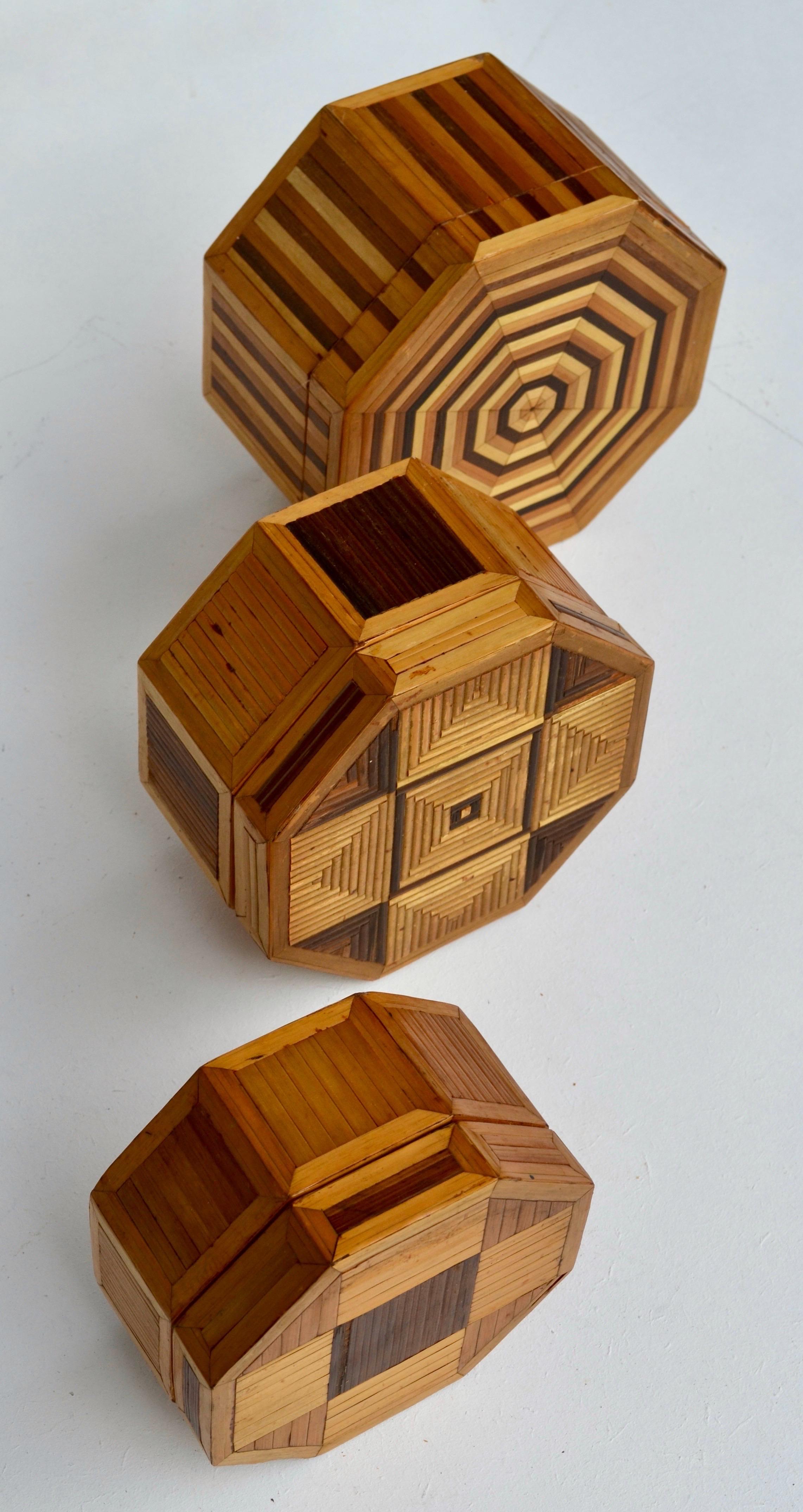 Ein seltenes und exquisites Set von drei französischen achteckigen Nistkästen mit Stroheinlegearbeiten auf Holz, handgefertigt um 1970 im raffinierten Geist von Jean-Michel Frank. Jeder Deckel zeigt ein einzigartiges geometrisches Motiv, das durch