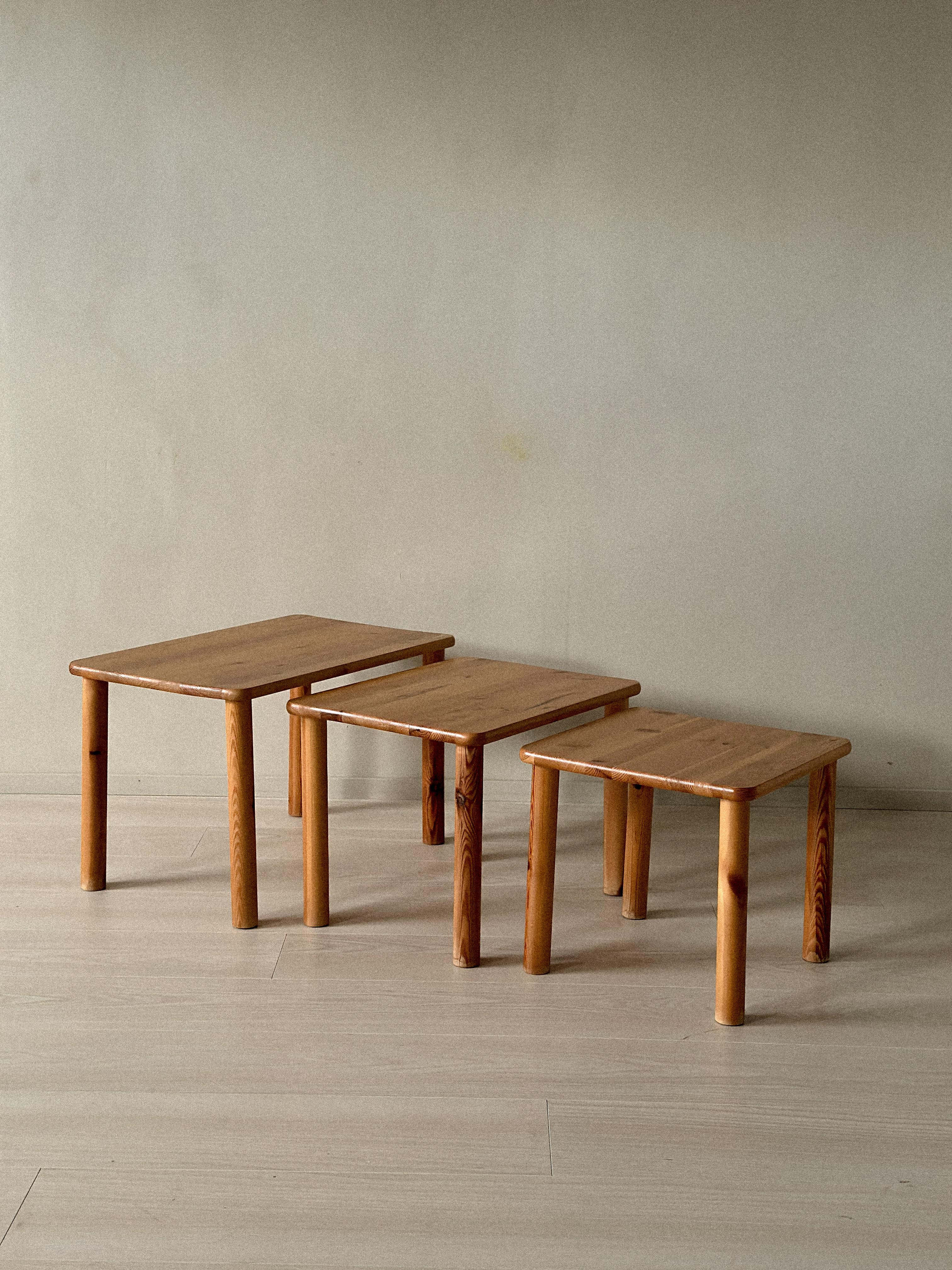 Ensemble de trois tables d'appoint en pin massif de Norvège, vers les années 1970. Design simple et fonctionnel avec des bords doucement arrondis et des pieds cylindriques, caractéristiques de l'artisanat scandinave de l'époque.

Surface laquée avec