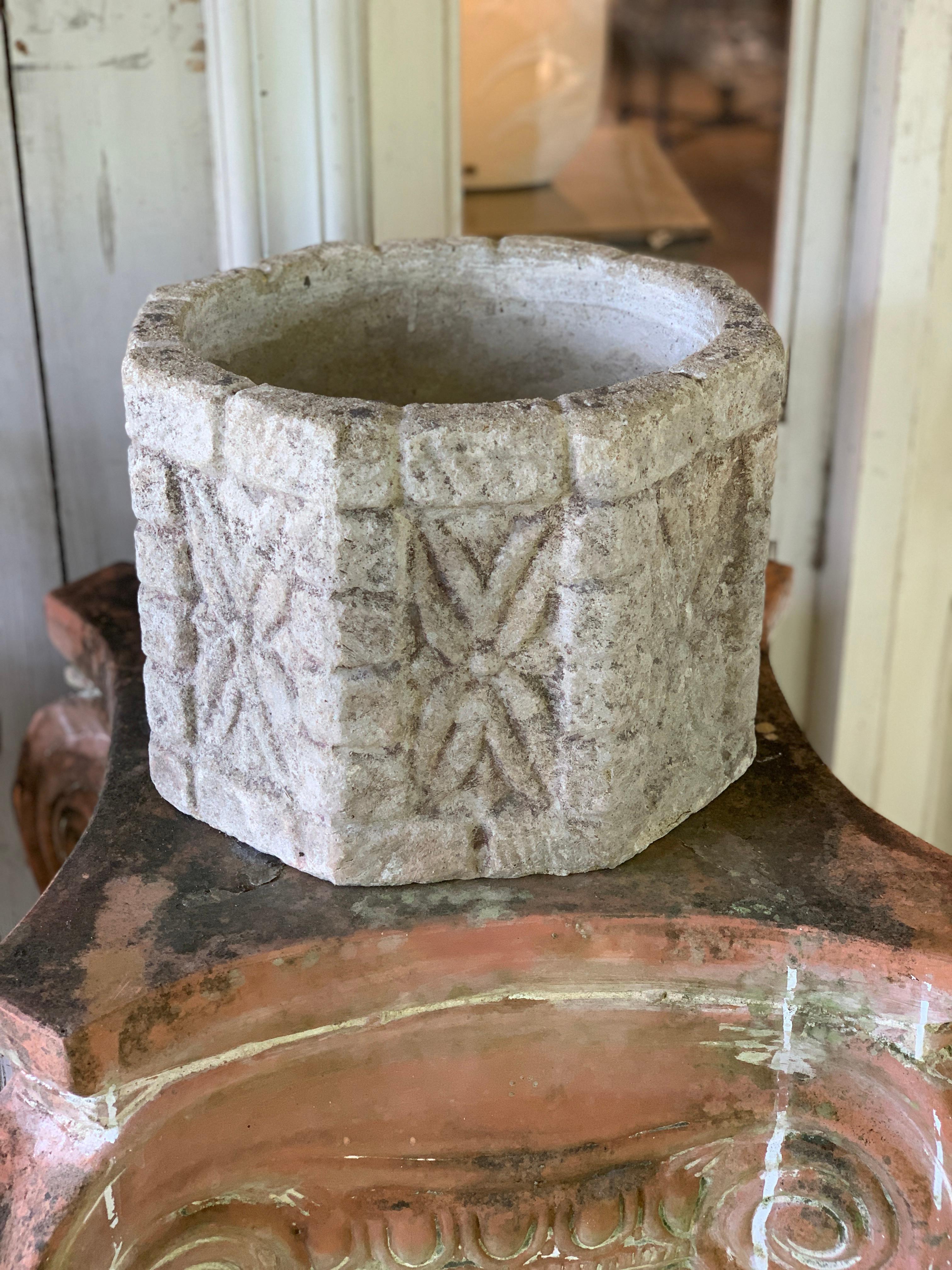 Ensemble de trois jardinières de forme octogonale, réalisées en pierre reconstituée joliment patinée. Chaque face de la jardinière est ornée d'un motif floral dont le degré d'altération varie, de sorte qu'il n'y en a pas deux identiques. Les