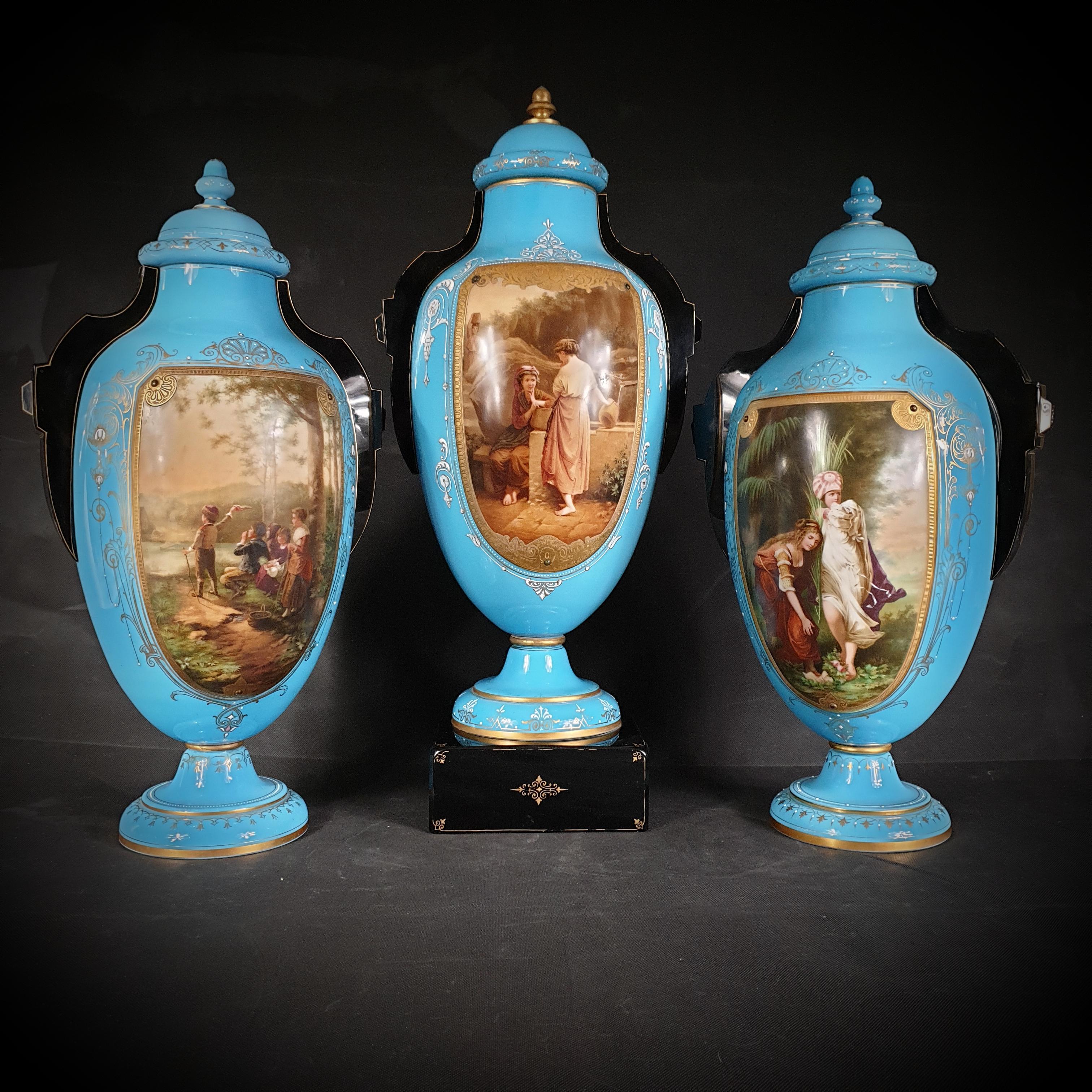 A spectacular collection of three painted and gilded blue opaline glass urns was created in Germany between 1845 and 1855. 
These stunning pieces have exceptional oval-shaped designs that are both elegant and captivating.
These exquisite urns are
