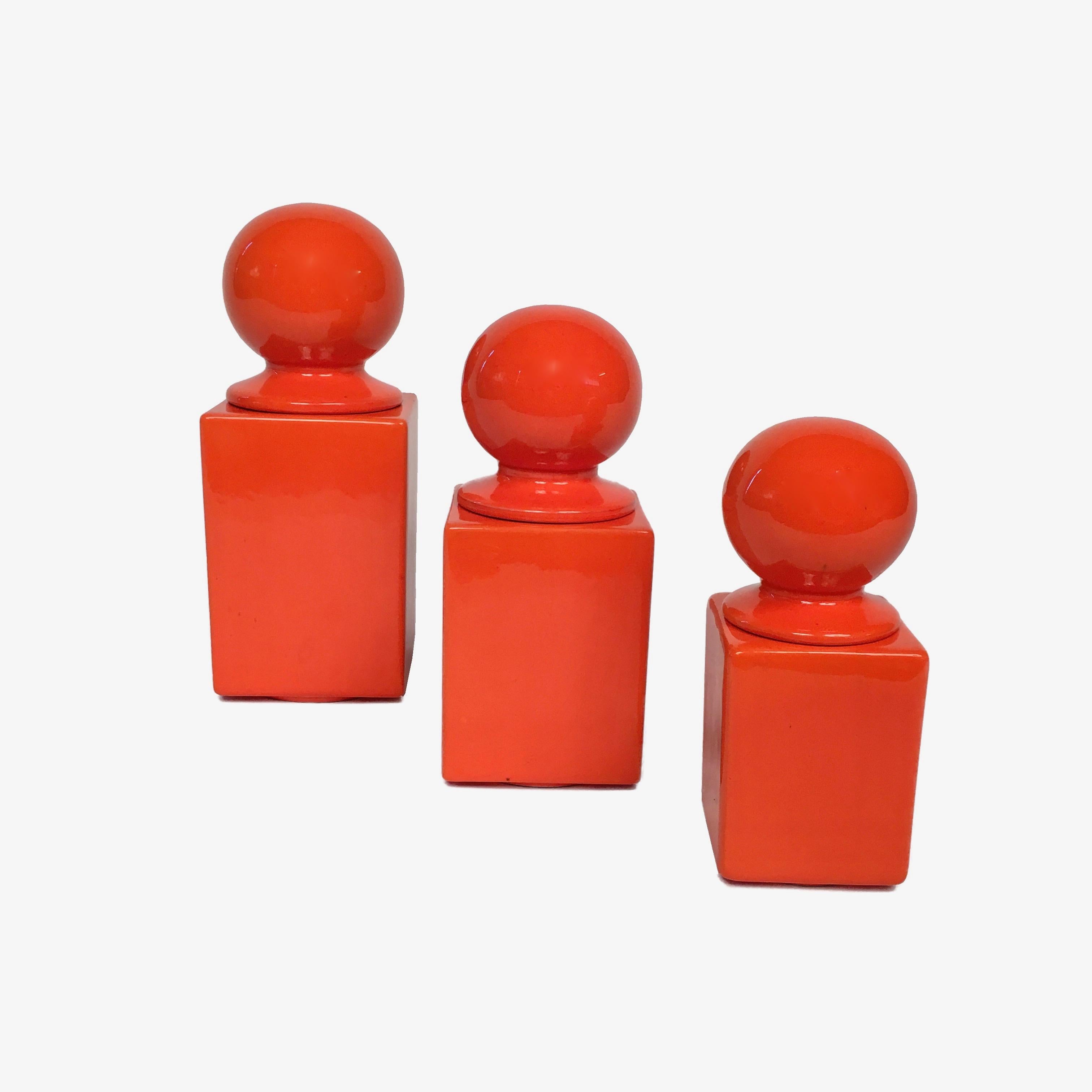 Set of three orange glazed ceramic boxes by Pino Spagnolo for Sicart, Italy. 
Each box has different dimensions, following an ascending order:
25 x 10 x 10 cm;
21 x 9 x 9 cm;
18 x 7.5 x 7.5 cm.
Conditions: excellent, except for the middle-sized