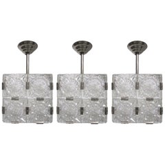 Ensemble de trois lampes suspendues originales en forme de cube, en verre taillé avec des pinces nickelées