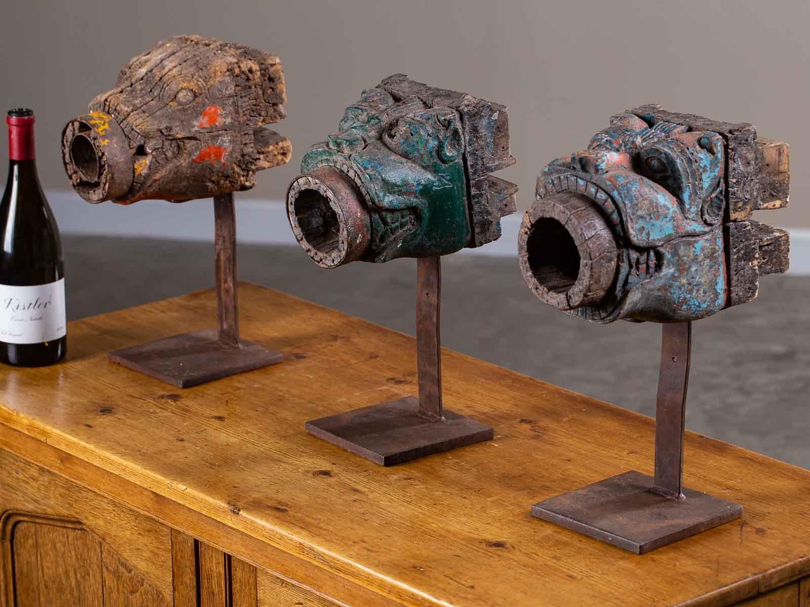 A set of three hand-carved and painted animal head sculptures circa 1890 Indonesia originally used at the top of a column to connect a crossbeam. We love the wonderful details of both the carving and the faded paint and imagine how terrific these