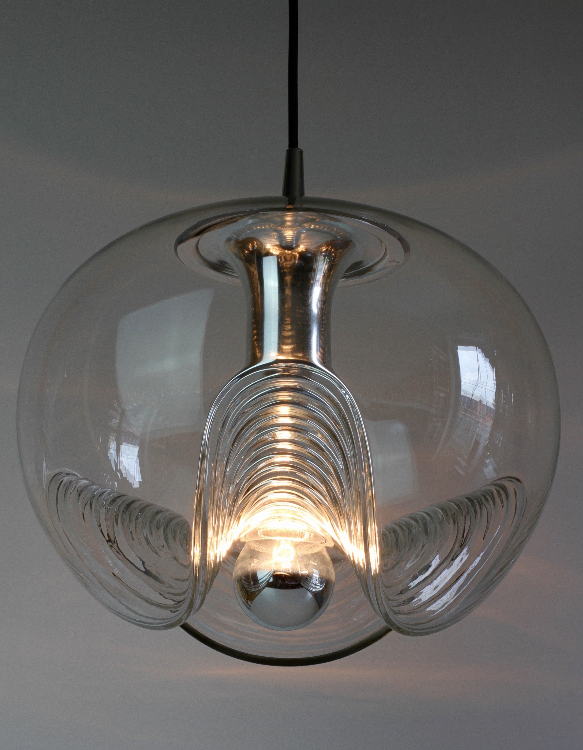 Set of three beautiful mid-century designed hanging ceiling pendant lights by iconic German lighting manufacturer Peill & Putzler in the 1970s. This is an absolutely classic piece of design, featuring a clear glass globe shade with a waved or ribbed