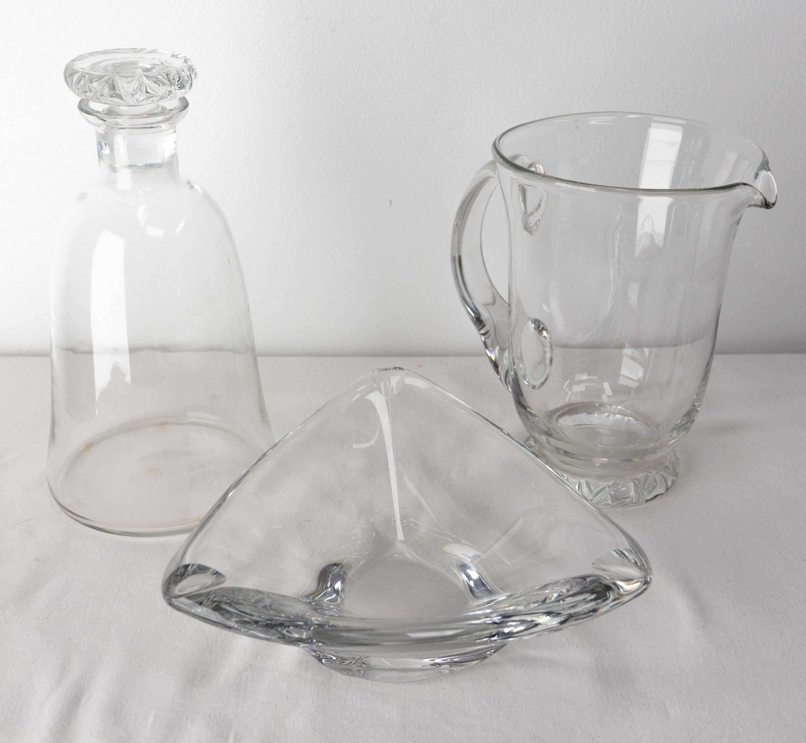 Set of three crystal creations from Daum France: an ashtray or centerpiece, two jugs : a water carafe and a wine carafe.
French, circa 1960
Good condition, with some marks of use, nothing disturbing.
Dimension of each piece:
Centerpiece: D 6.89 in.,