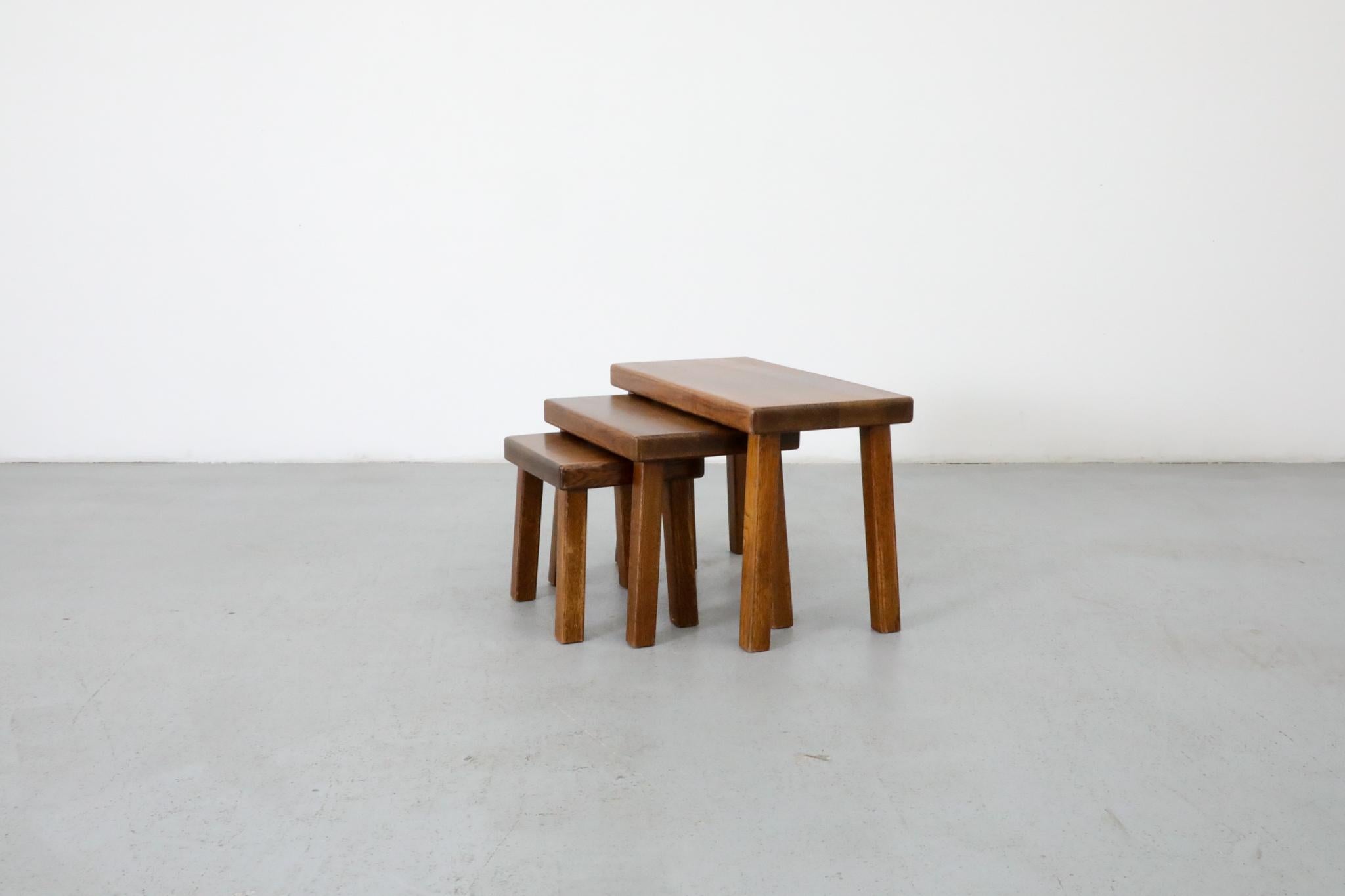 Ensemble de 3 tables gigognes en chêne de style Pierre Chapo. La grande table mesure 23,75 x 12 x 15,75, la moyenne 17 x 12 x 13,75, la petite 11,75 x 10,25 x 11,75. Légèrement restauré, avec quelques traces d'usure dues à l'âge et à l'utilisation.