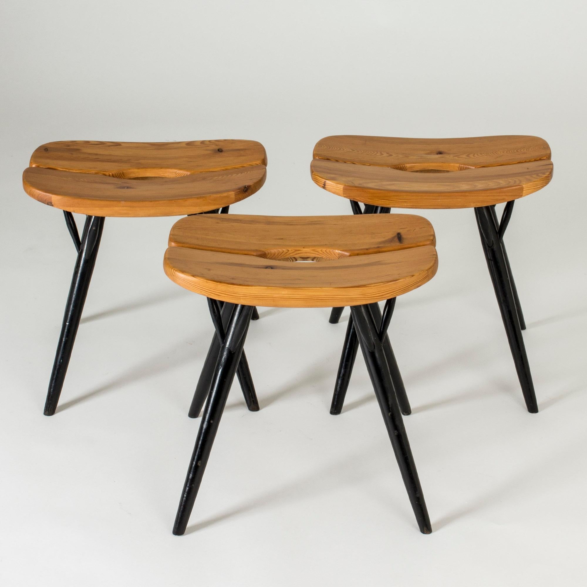 Set of three stools by Ilmari Tapiovaara, from the furniture line “Pirkka”. Cool, rounded design with pine seats and black lacquered legs.