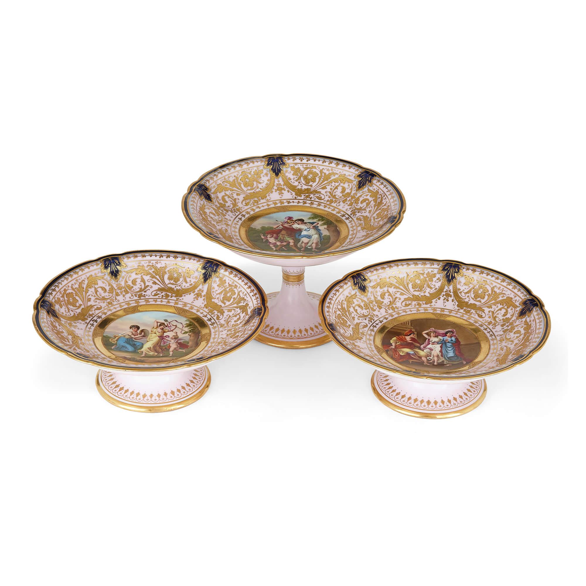 Set of three porcelain tazze by Royal Vienna
Austrian, early 20th century
Larger tazza: Height 15cm, diameter 34cm
Smaller tazze: Height 9cm, diameter 34cm

This elegant set of three tazze (a tazza being a plate raised on a socle) is by Royal