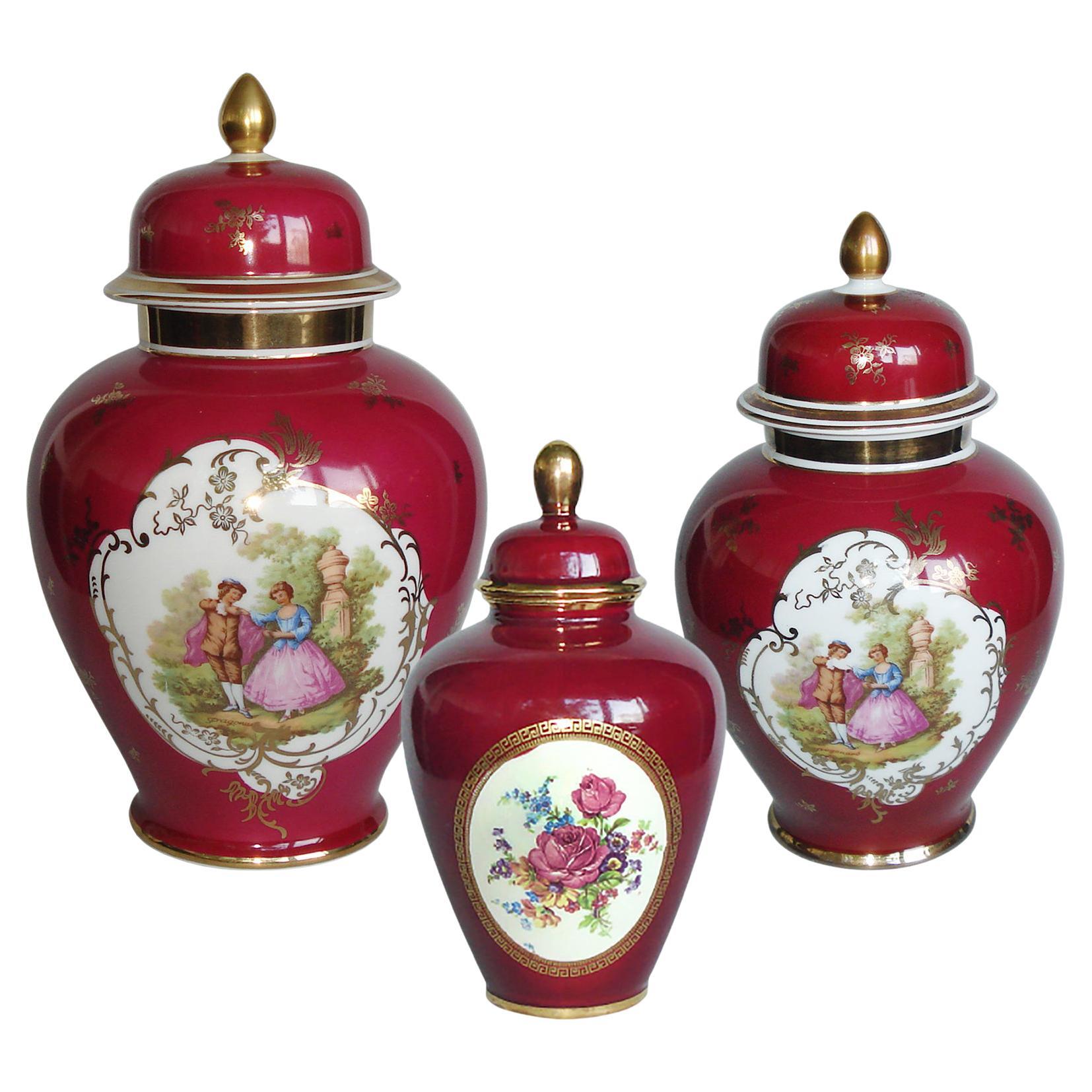 Ensemble de trois urnes en porcelaine avec couvercle, peintes à la main avec des scènes de ragonard