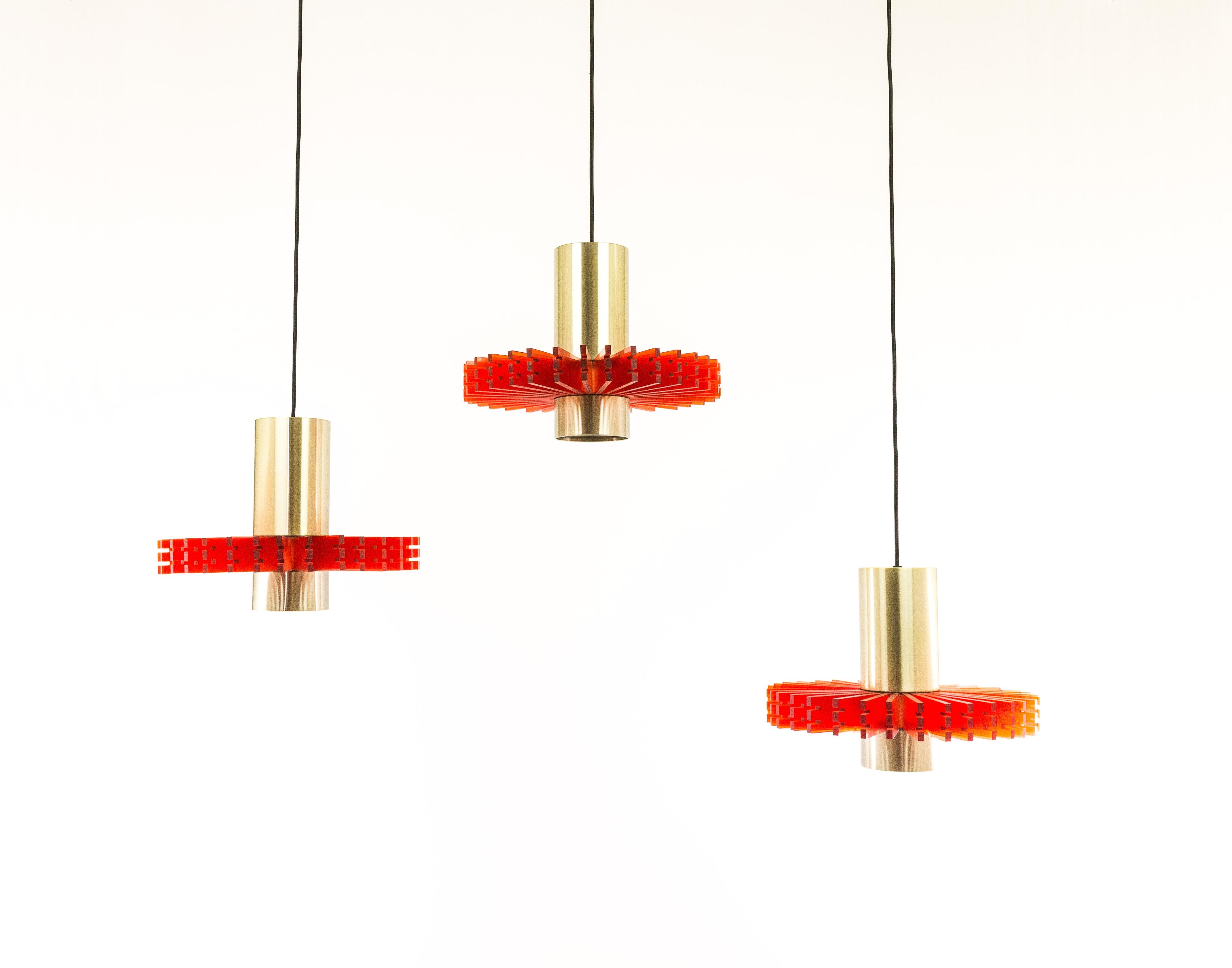 Set of three aluminium and acrylic pendants, nicknamed 'Priest collar', designed by Claus Bolby for Danish lighting manufacturer Cebo in -most probably- the 1960s.

Each pendant consists of two round brass colored aluminium elements which are