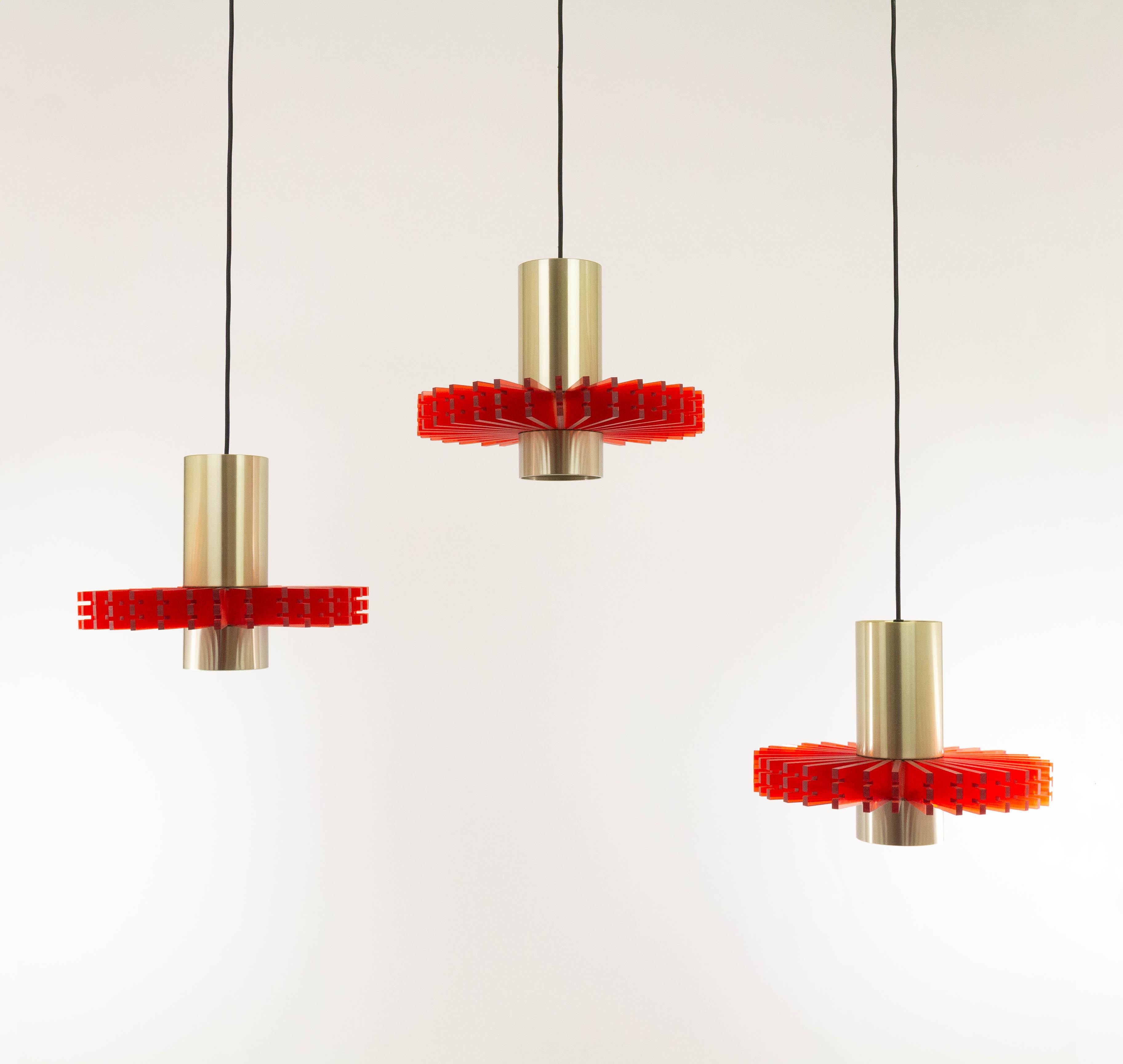 Set of three aluminium and acrylic pendants, nicknamed 'Priest collar', designed by Claus Bolby for Danish lighting manufacturer Cebo in -most probably- the 1960s.

Each pendant consists of two round brass colored aluminium elements which are joined