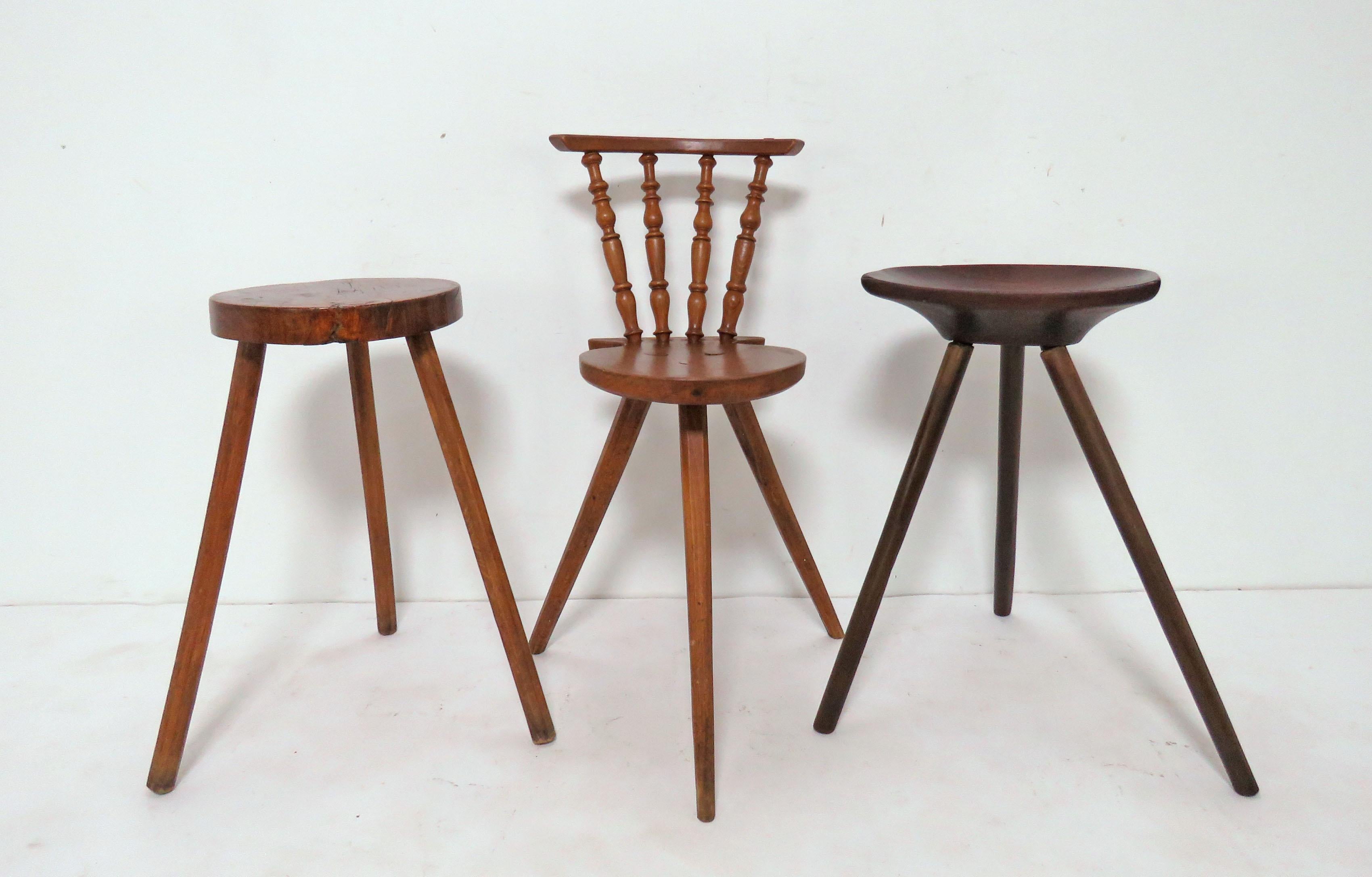 An assorted collection of handmade primitive stools with tripod legs, circa 19th and 20th century. Included is a walnut live edge stool circa 1870s, seat made from a slice of trunk; a wonderful Windsor back fashioned of chestnut circa mid-19th