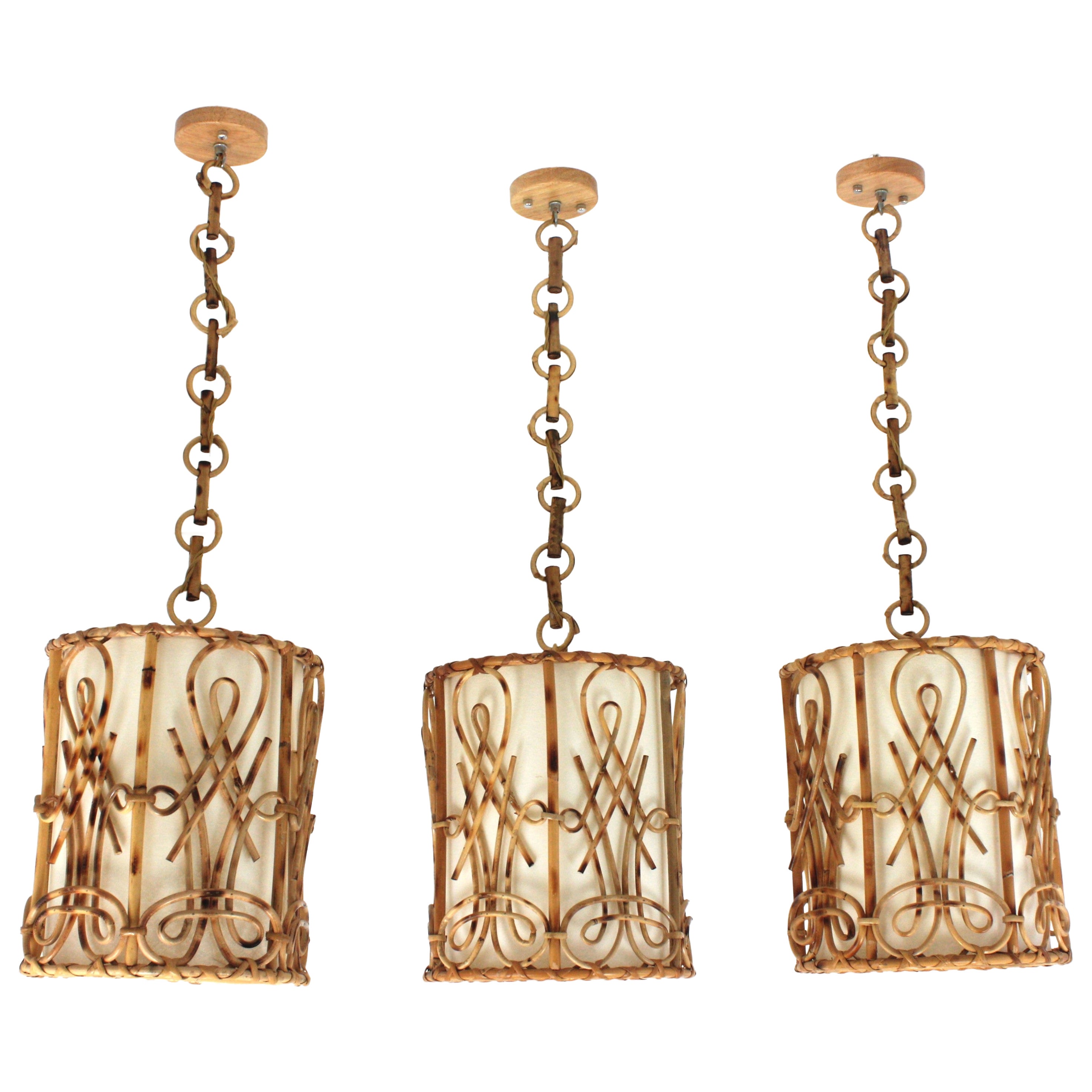 Lot de trois lampes pendantes / lanternes cylindriques en rotin, style Chinoiserie en vente