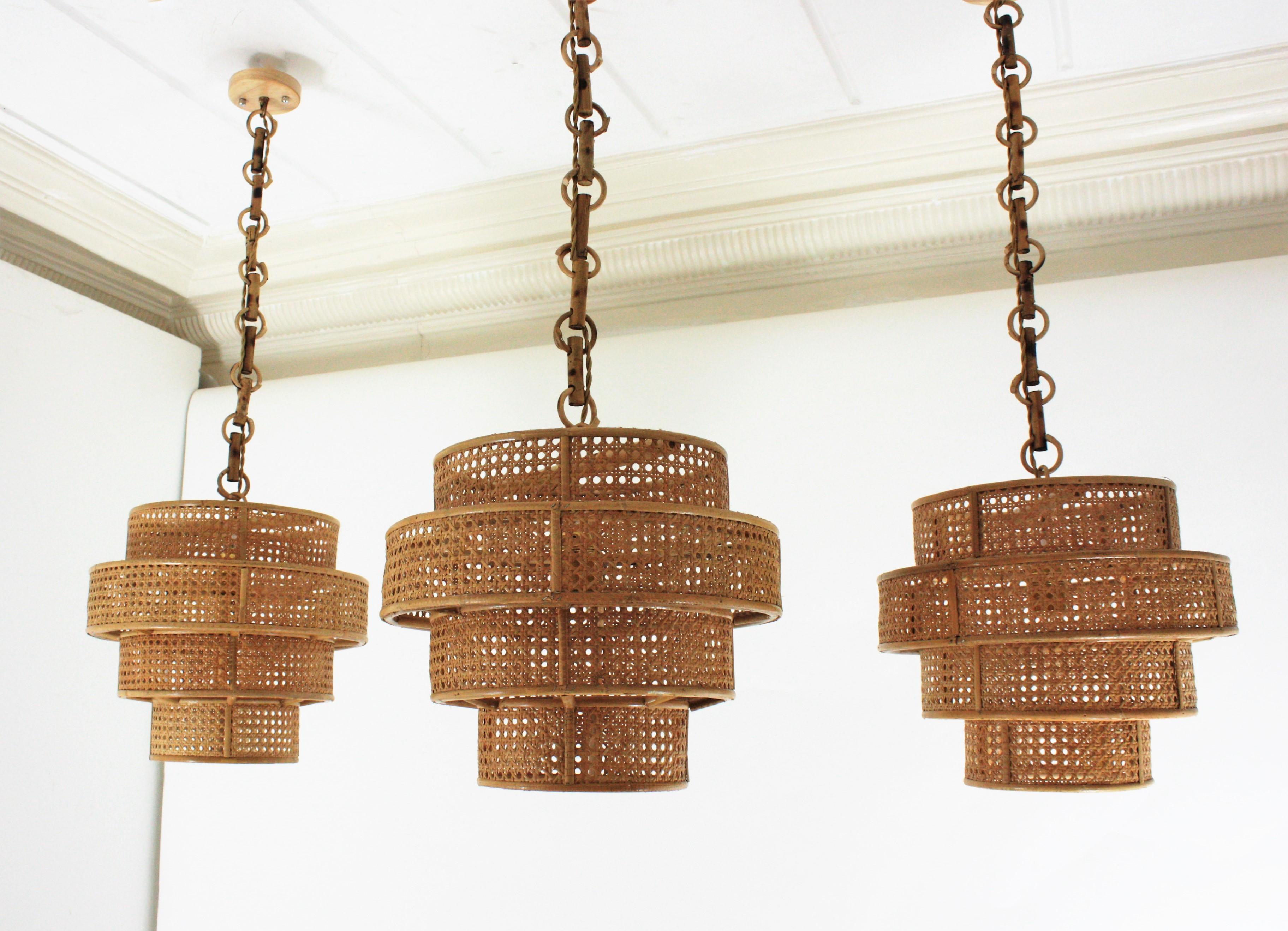 Mid-Century Modern Set of Three Rattan Wicker Weave Cylinder Pendant Lights / Lanterns For Sale