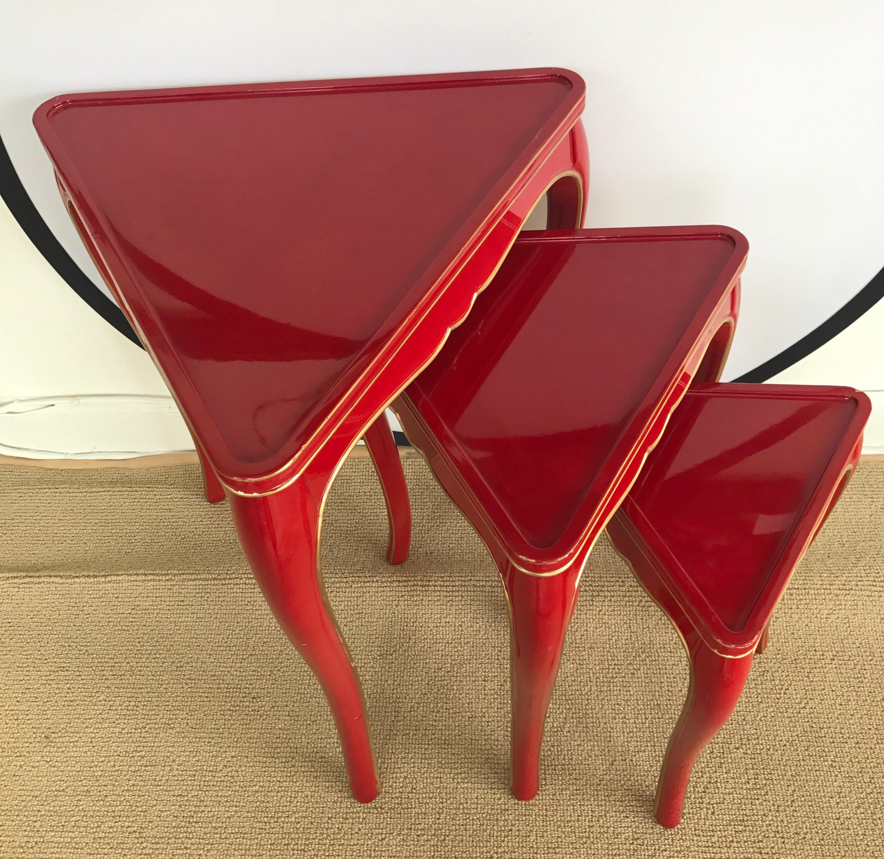 Elegant set of three matching red lacquered nesting tables that have graduating heights of 26