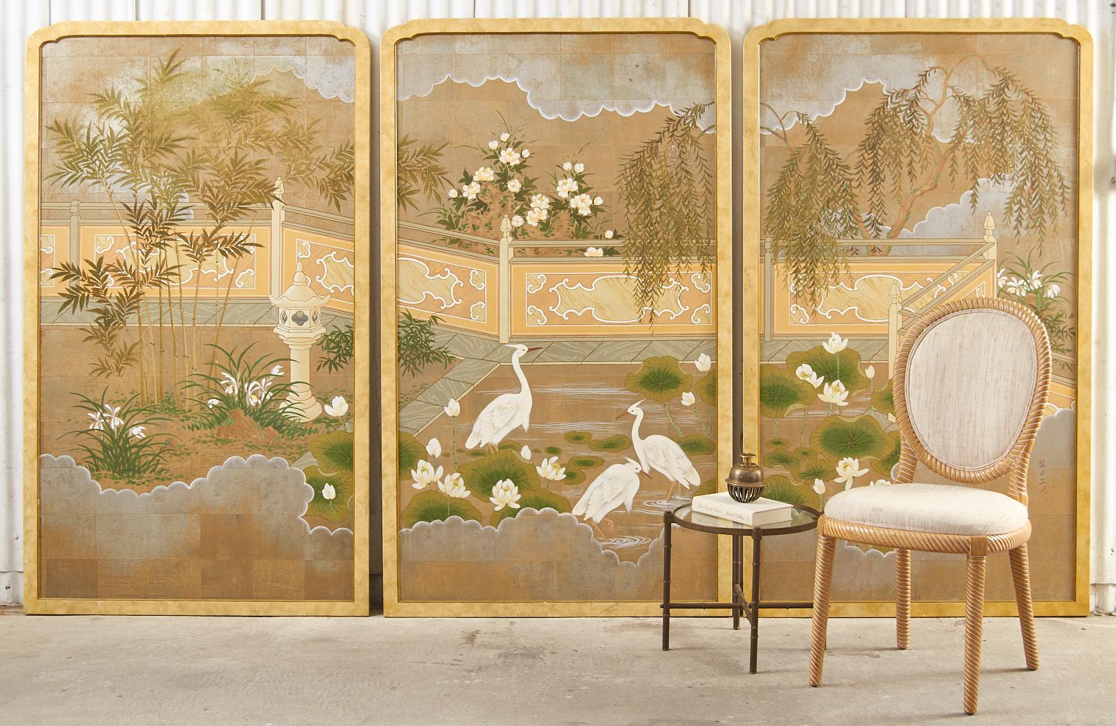 Fantastic set of three framed chinoiserie decorated landscape panels painted by Robert Crowder (1911-2010 American). The paintings feature a flora and fauna garden centered by white egrets in a pond with lotus blossom. The scene is painted over a