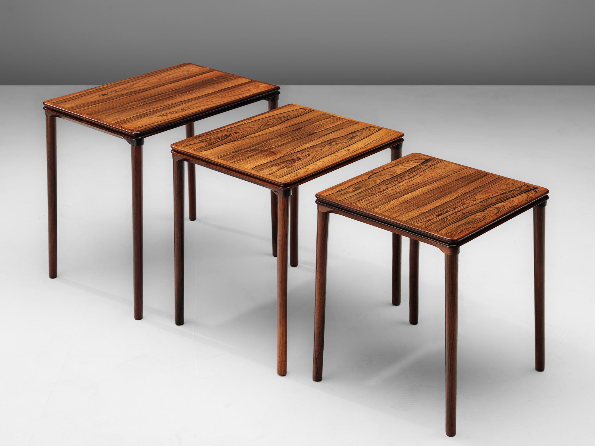 Nesting tables, in rosewood, Scandinavia, 1960s. 

Nest of three tables is rosewood. With a tight base of slats, beautifully connected with wood joints. The rectangular top has a nice trim which emphasize the grain of the rosewood, the legs are