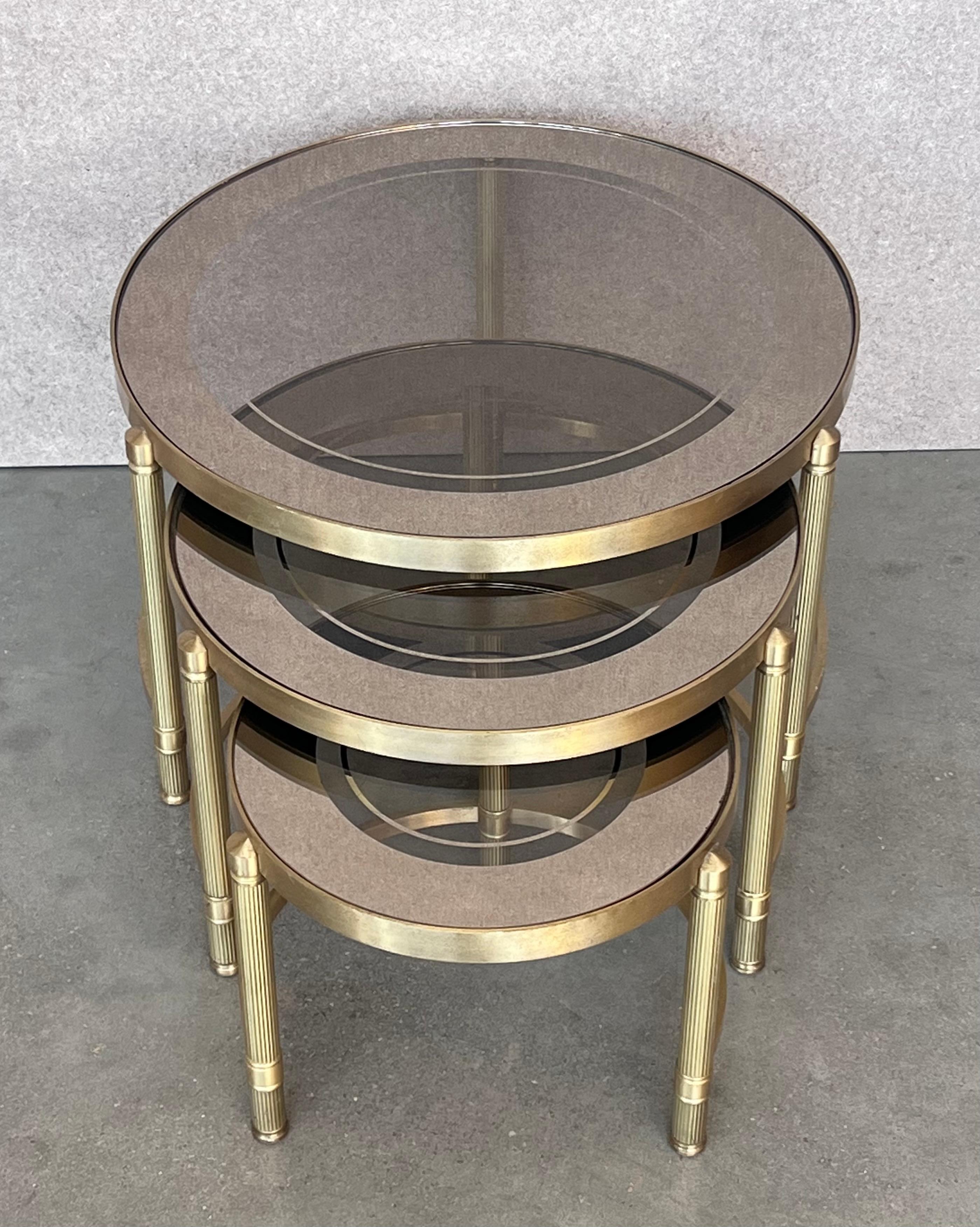 Art Deco Set of Three Round Brass Nesting Tables with Smoked Pink Glass Tops For Sale