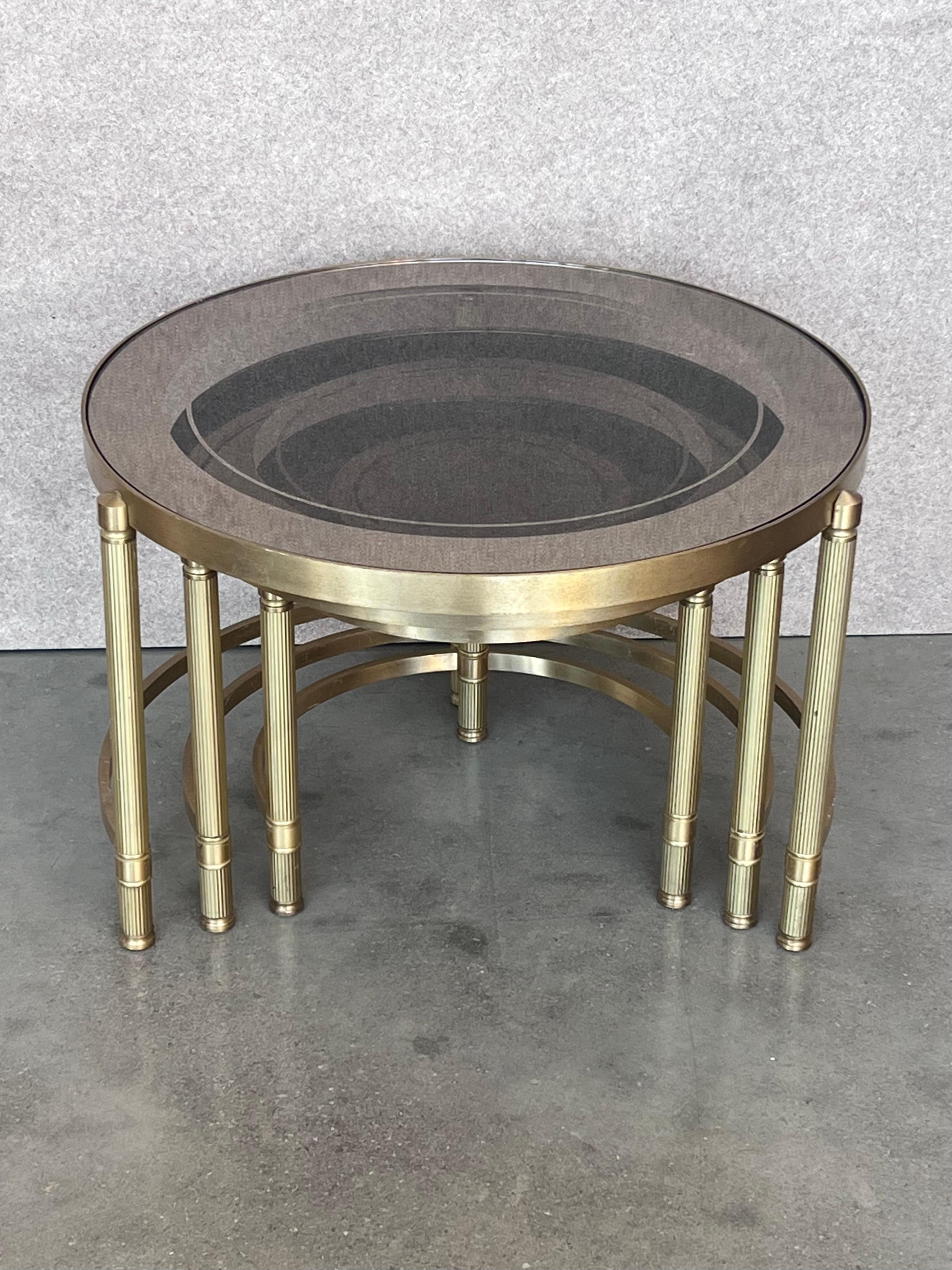 European Set of Three Round Brass Nesting Tables with Smoked Pink Glass Tops For Sale