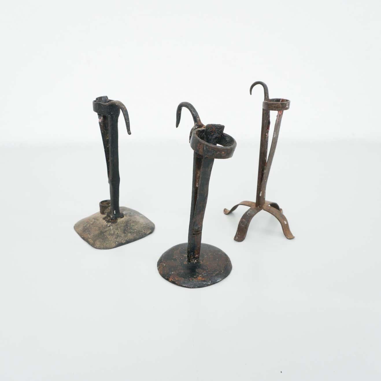 Set of three rustic metal candle holders, circa 1930
By unknown manufacturer. Spain.

In original condition, with minor wear consistent with age and use, preserving a beautiful patina.
 