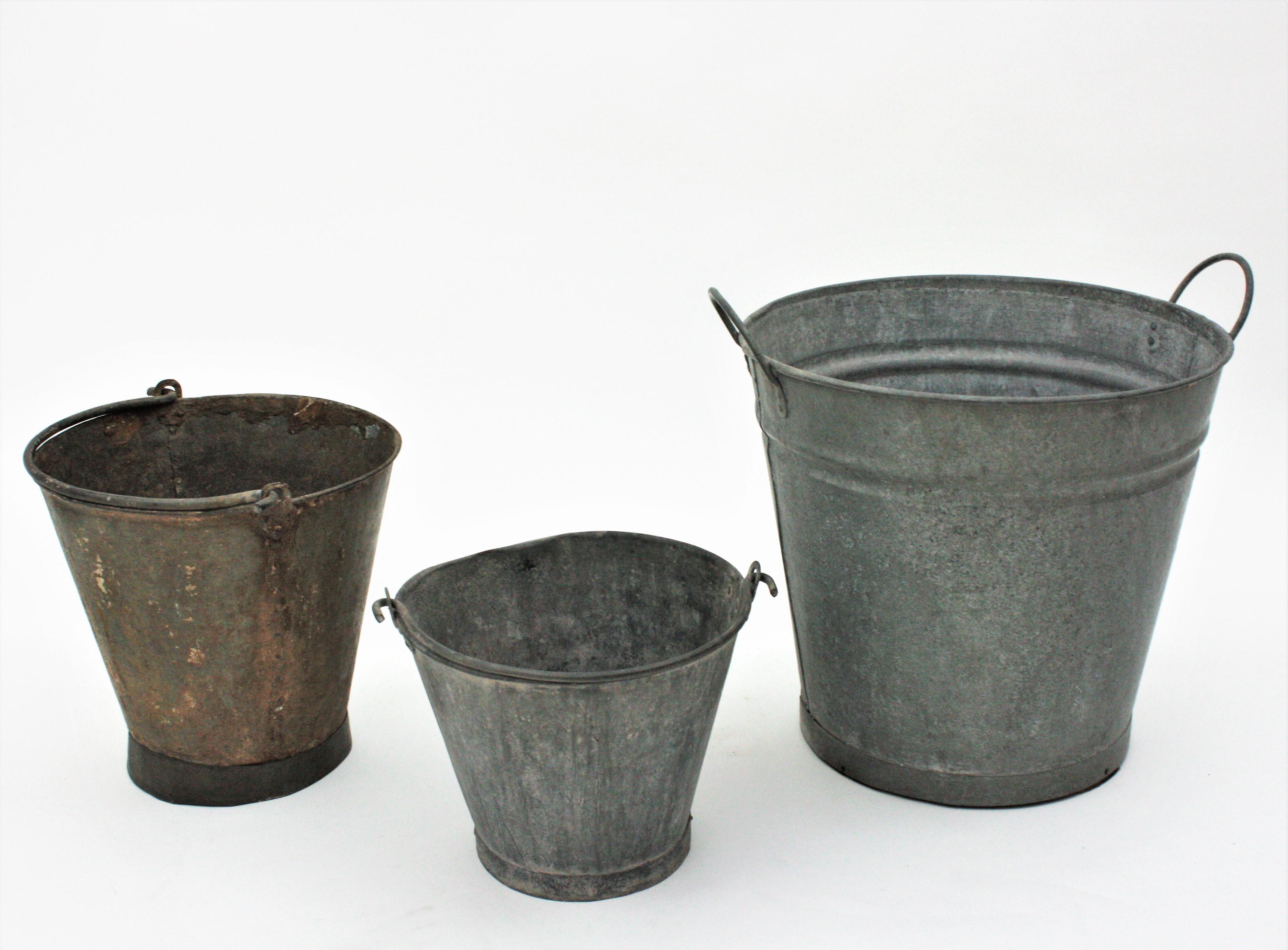 Set of Three old zinc buckets. Spain, 1940s.
For storage, gardening and decorative purposes at home or for window dressings.
The large one has two handles and the other ones have a folding single handle.
Measures ( including handles)
Large: 47