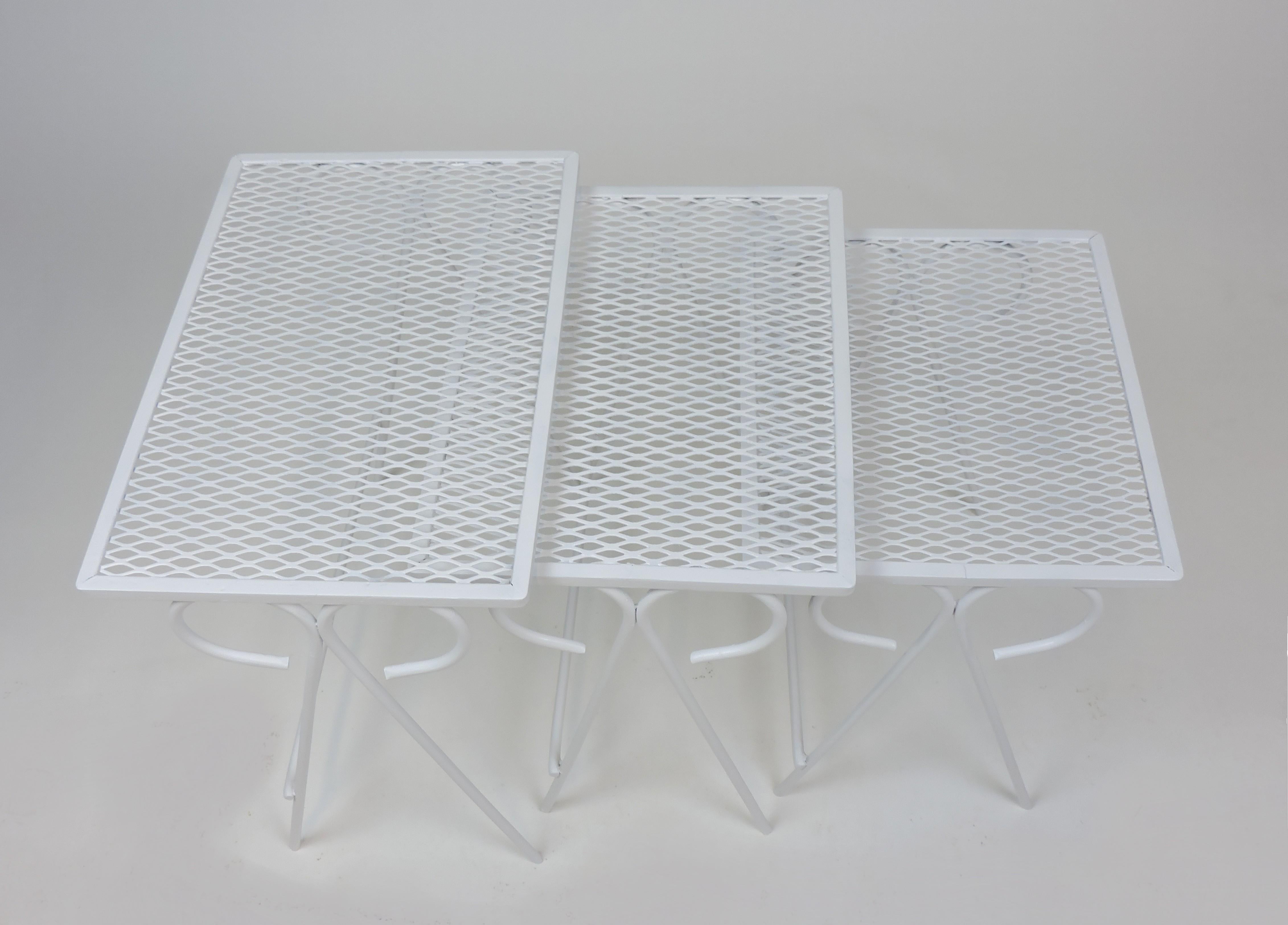 Beautiful set of three wrought iron patio nesting tables attributed to Salterini. Sturdy and well made, these have a fresh coat of white paint. Perfect for summer entertaining.
  