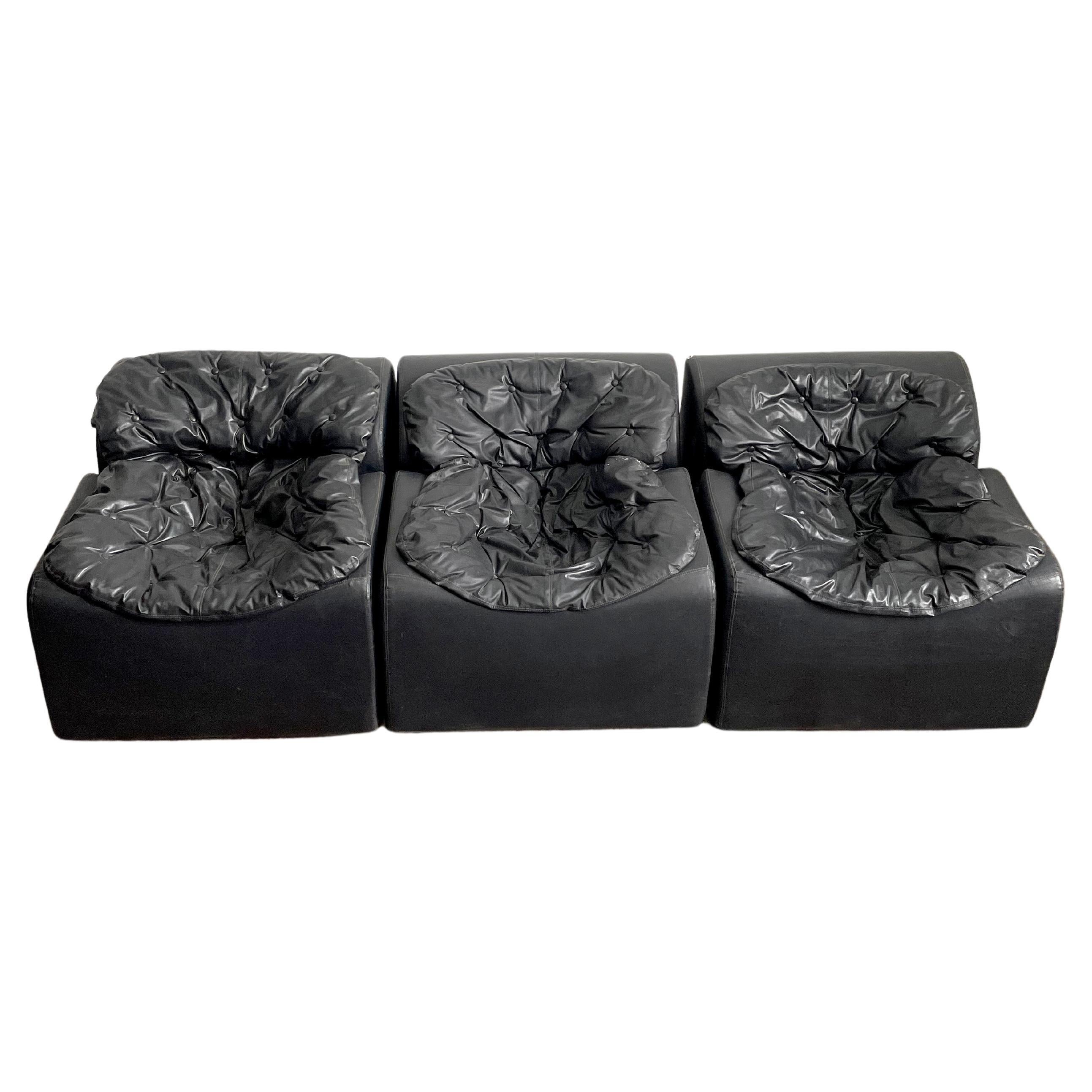 Very rare modular seating group consisting of 3 bloc-shaped lounge chairs upholstered in black faux leather 

The name of this model is 'Kim' and it was manufactured by Belgian furniture maker Beka in the late 1960s or 1970s

Remains a