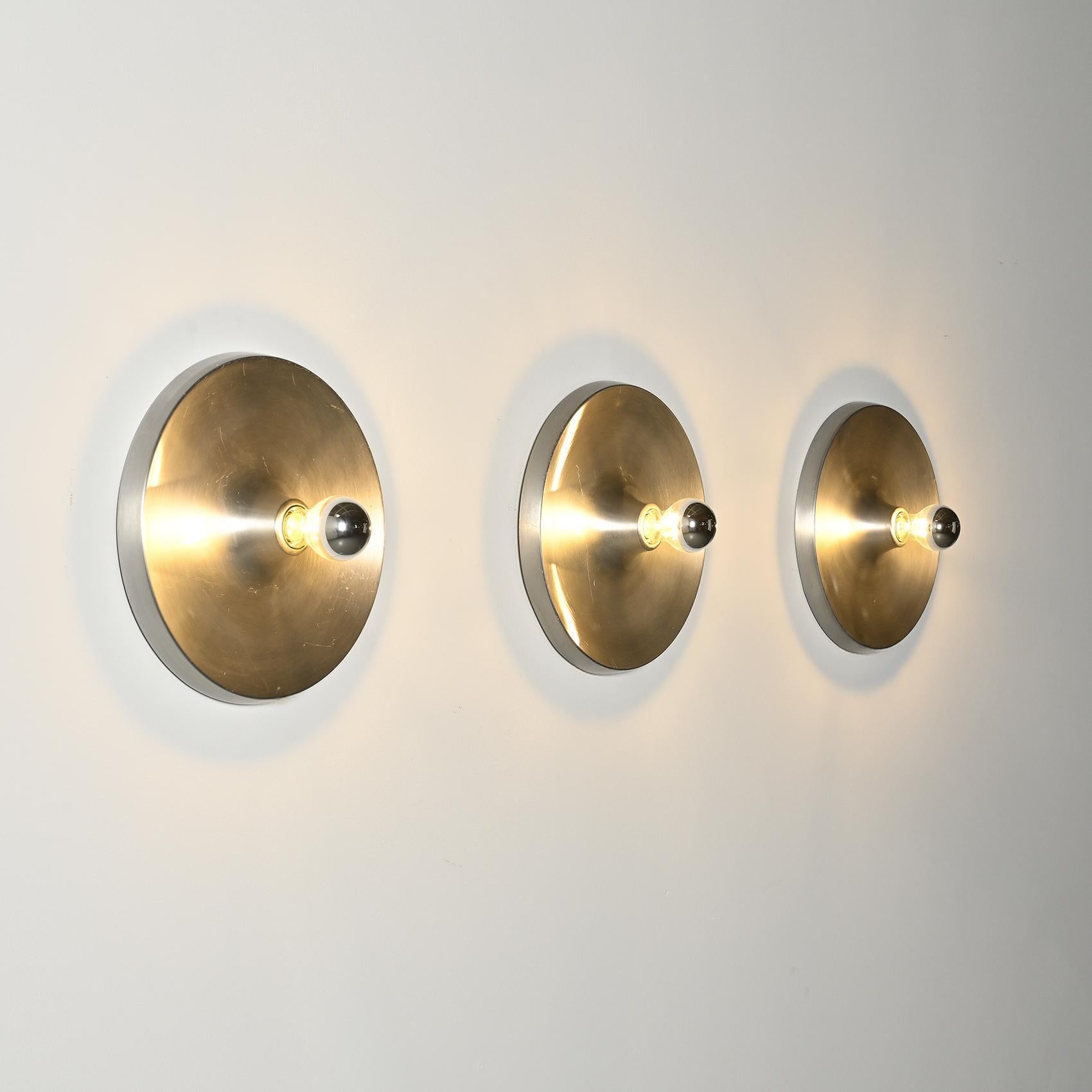
Passionate about the mountains, Charlotte Perriand devoted nearly 20 years of her life to the architectural and development project of the Les Arcs ski resort.

This set of circular wall lights in brushed aluminium was selected by her to furbish