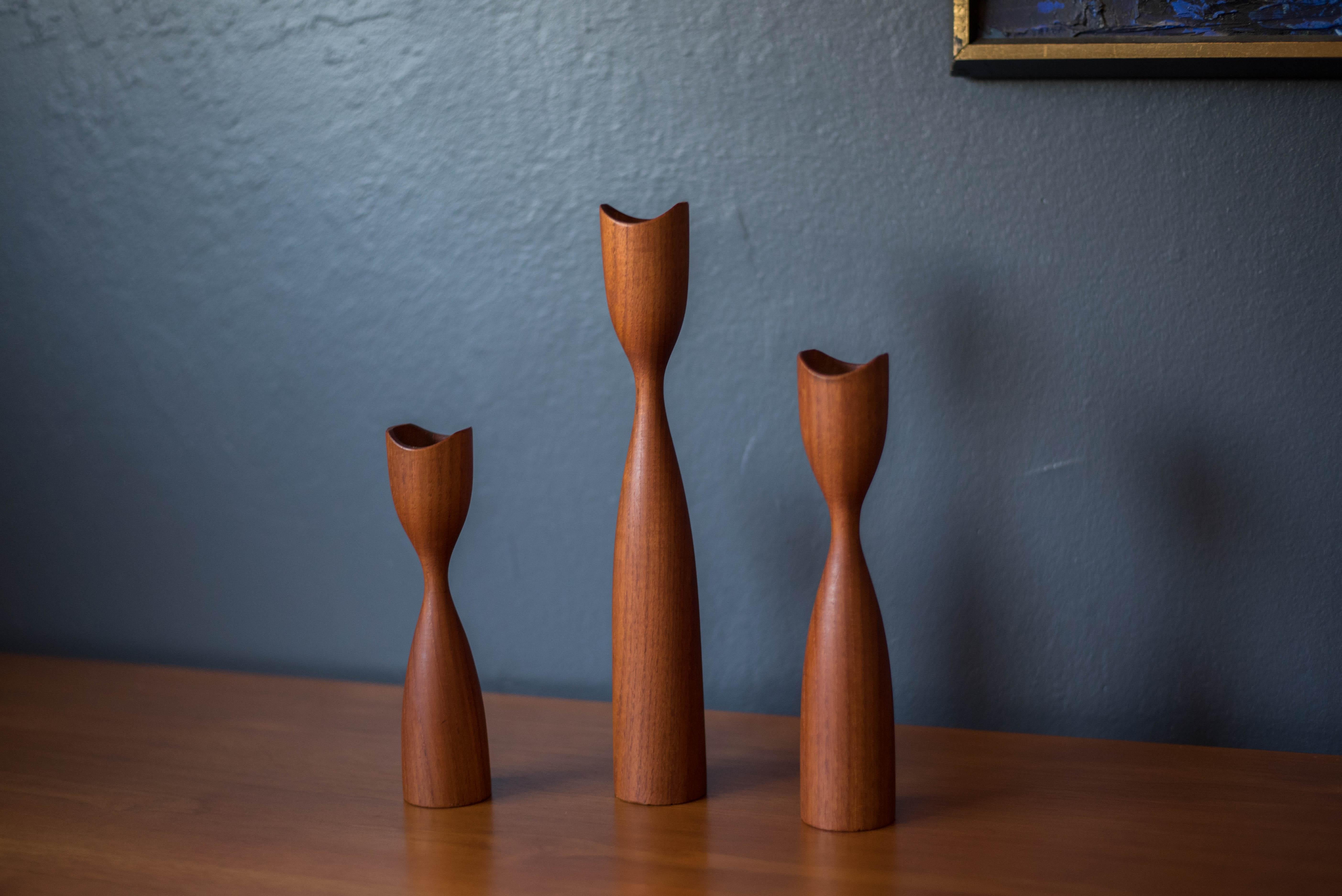 Vintage Scandinavian modern sculptural set of three teak candleholders circa 1960's. This set comes in three different sizes and displays well with any modern home decor. Fits 7/8