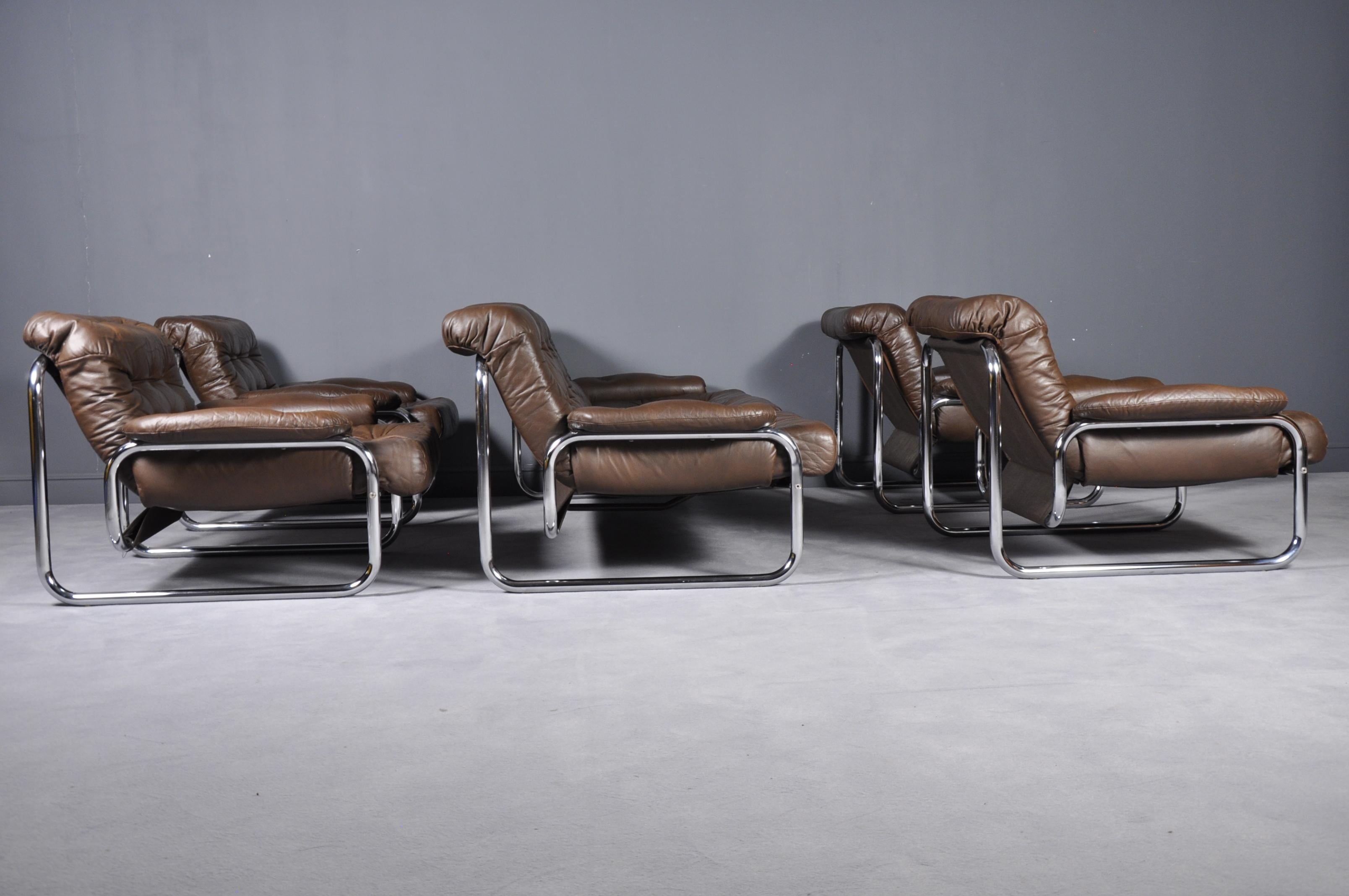 Swedish Set, 1970s tubular metal framed lounge sofa and four armchairs with original brown tufted cushion and armrests. Produced by Ikea, model Troligen, designed by Johan Bertil Häggström.Set contains four armchairs and one three-seat