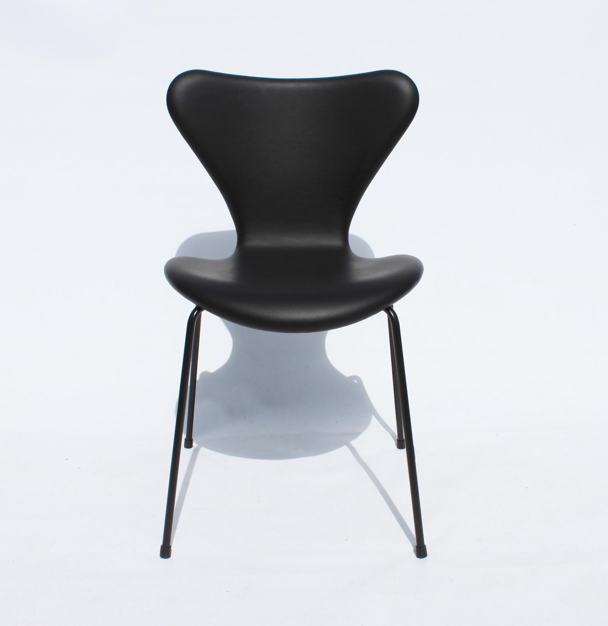 Set of three series seven chairs, model 3107, designed by Arne Jacobsen and manufactured by Fritz Hansen I 2016. The chairs are a special model with original upholstery of black leather and black frame.
 