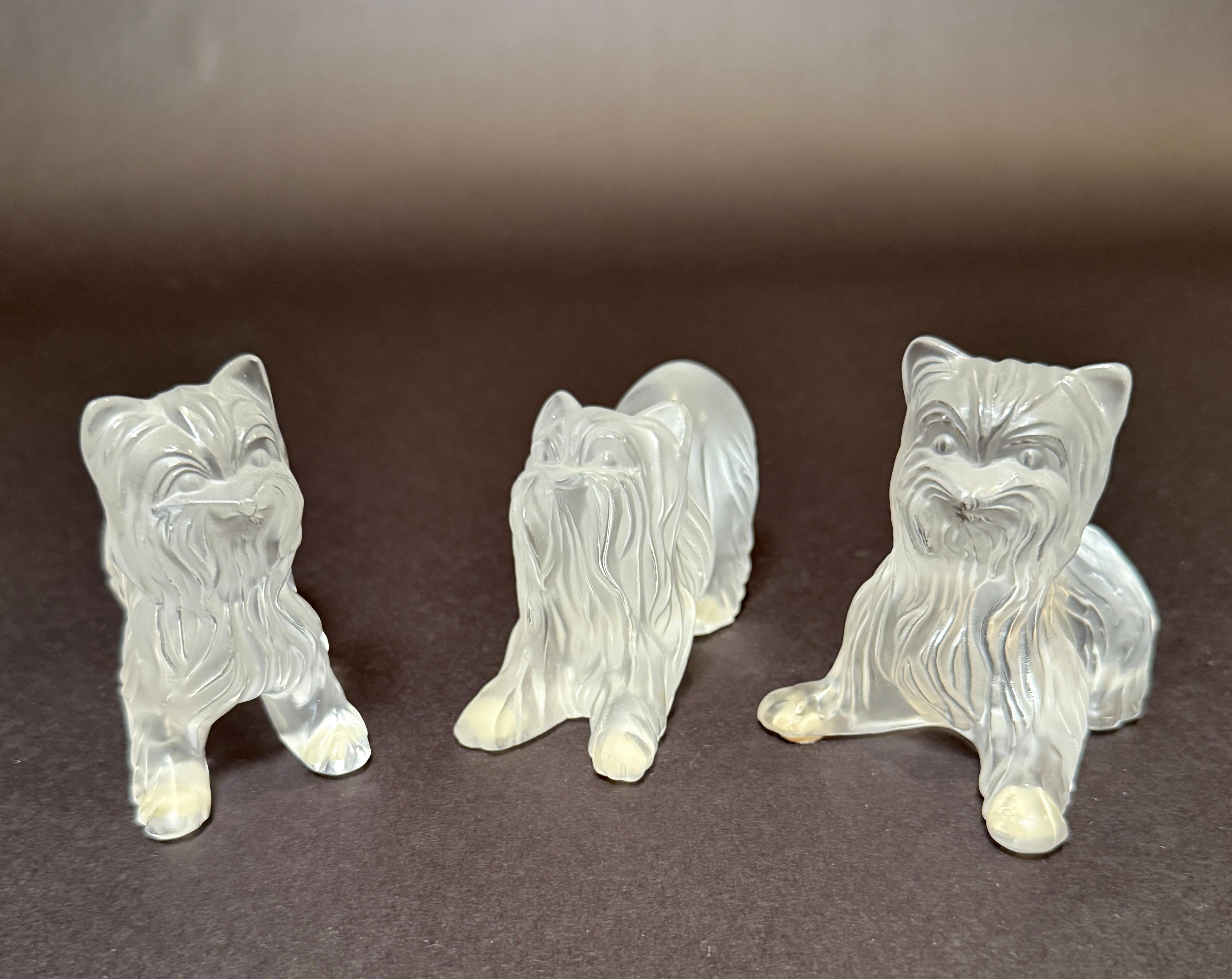 Un affascinante set di tre statuette di Yorkshire Terrier in vetro smerigliato di Lalique, Francia, ciascuna firmata sulla base. Realizzati con maestria, questi pezzi mostrano l'attenzione di Lalique per i dettagli, con pellicce finemente modellate,
