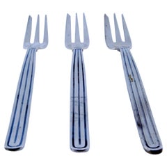Set of three silver cake forks w/ three tines
raised trim along the handles