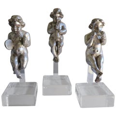 Ensemble de trois chérubins musiciens en argent doré sur socles en lucite