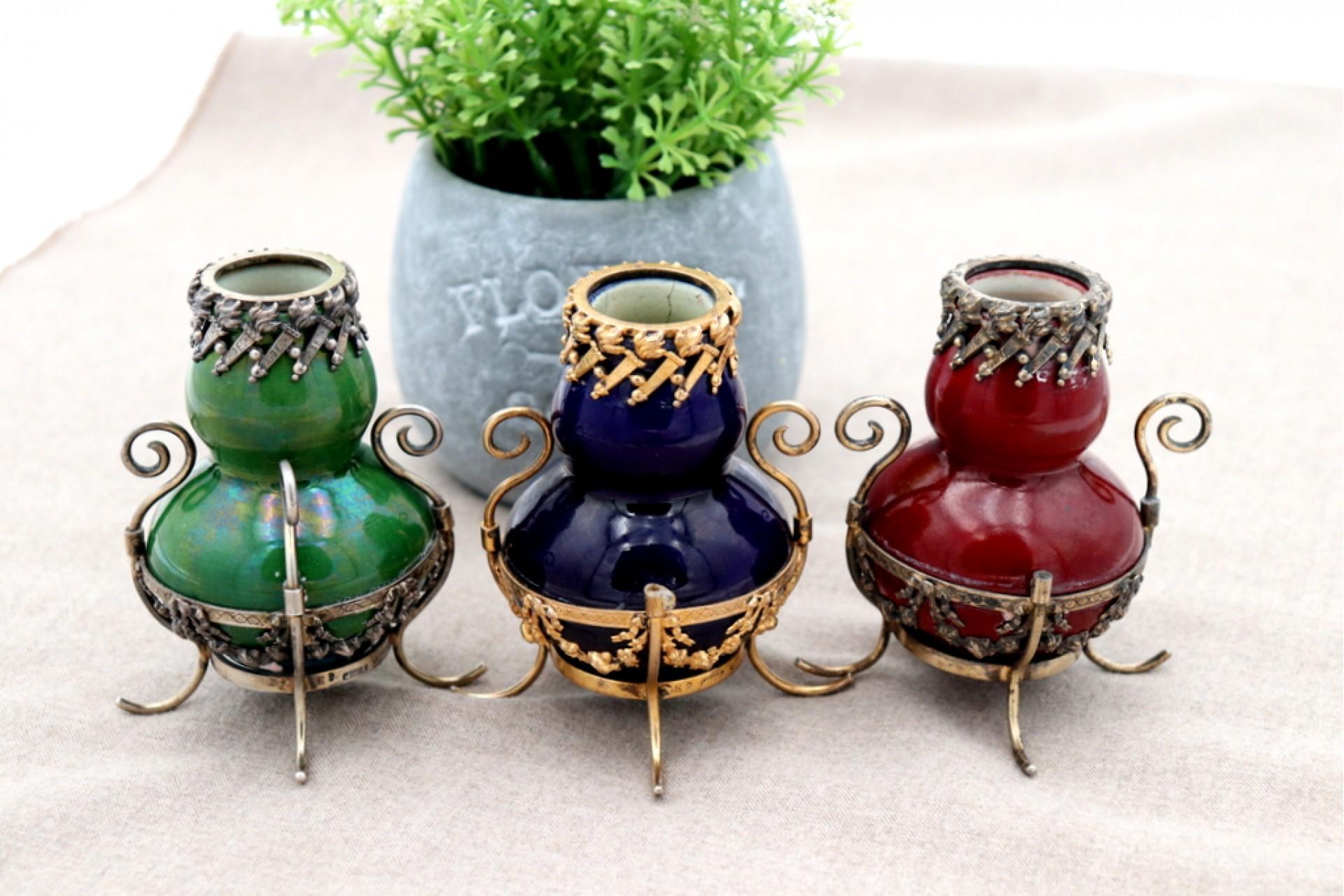 Description: Set of three small porcelain jars with a silver structure embossed with torches, garlands, scrolls and applications. Metal: Silver. Origin: Portuguese. Brand: Javali I Title. Weight: 368.75 grams. Dimensions: 6cmx9cm. Content: 916/1000.