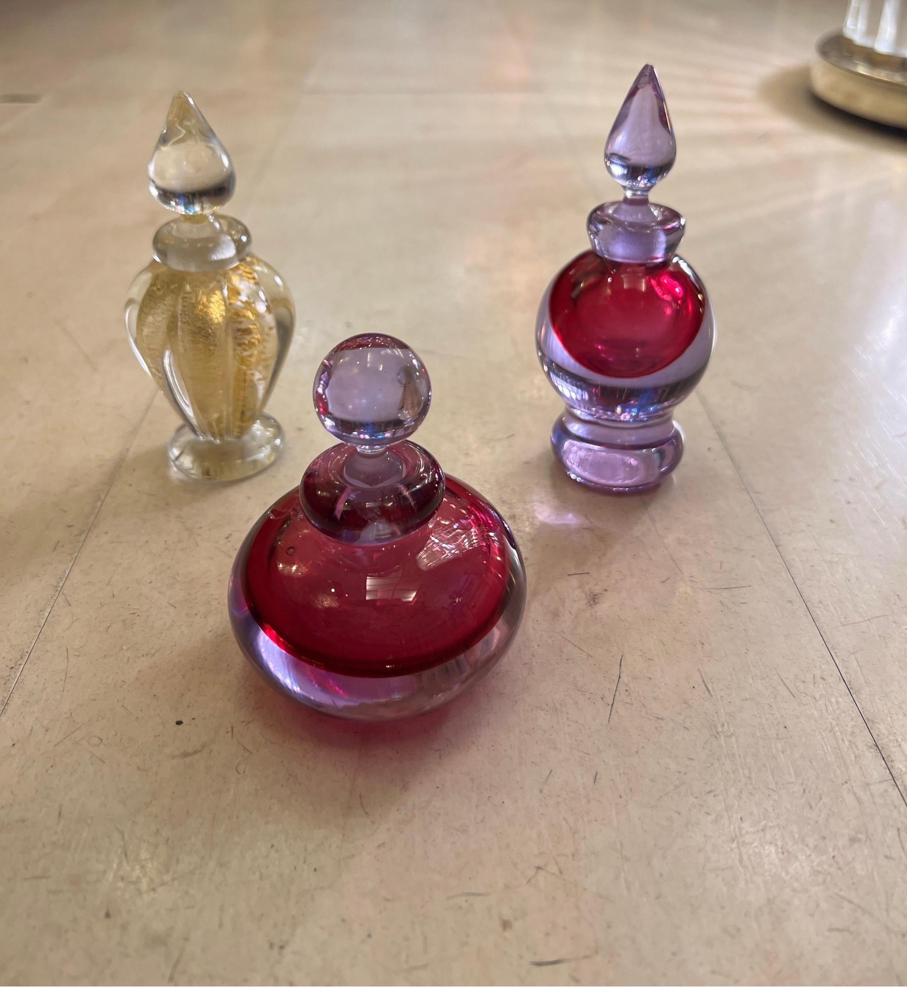 Set of three sommerso perfume bottles in gold and pink colors. Made in Italy, attributed to Archimede Seguso. The technique of blowing Murano glass is called 