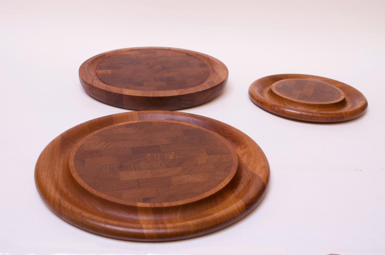 Jens Quistgaard for Dansk teak carving boards with checkerboard cutting surfaces (Denmark, circa 1965).
Includes three boards in total: one large round board, one smaller board, and one round, asymmetrical board, which is elevated to one side. All
