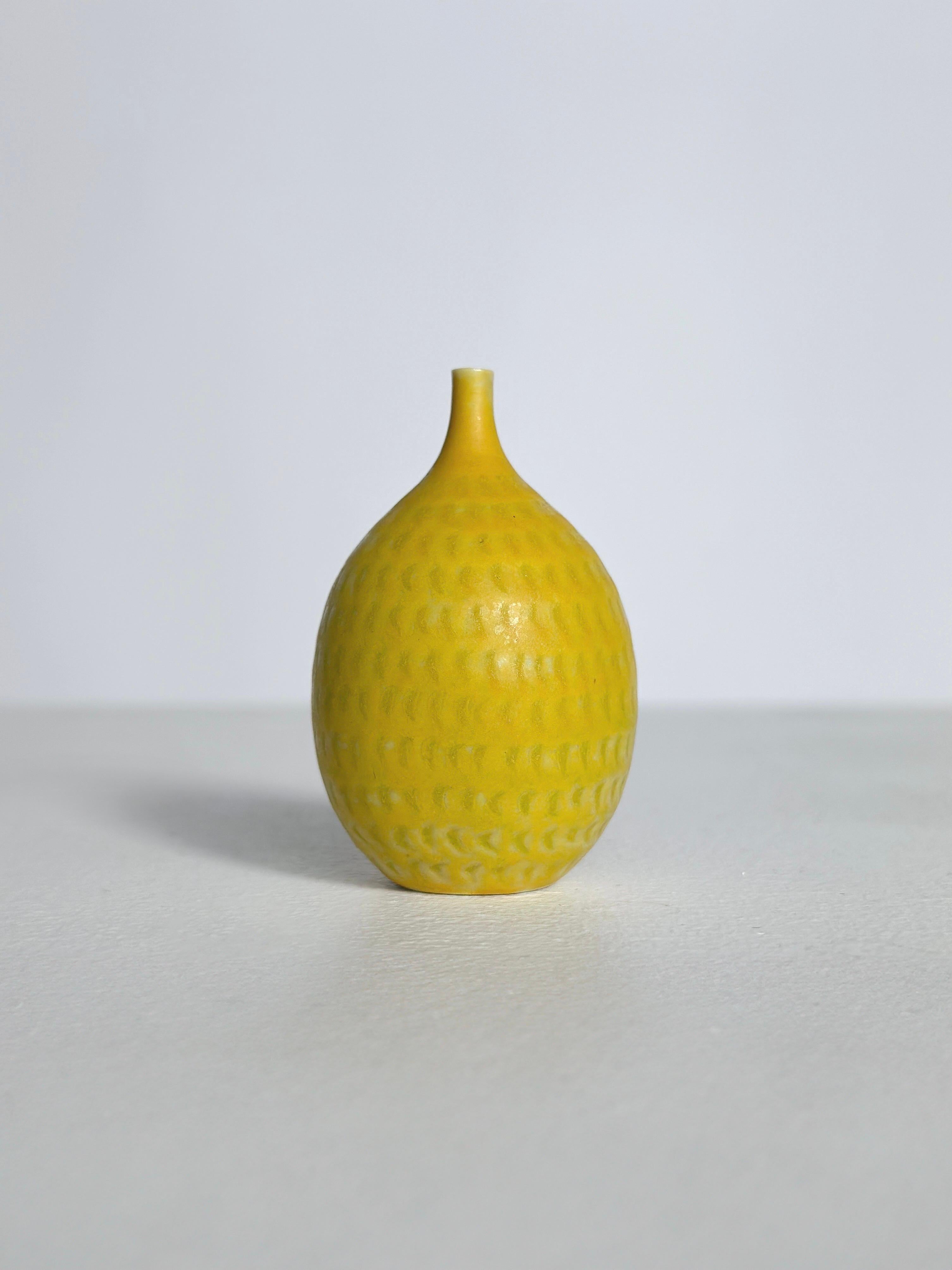 Juego de tres jarrones en miniatura de Stig Lindberg para Gustavsberg Suecia en la década de 1960.

Jarrón con forma de limón: A 6 cm, P 3,5 cm, 1962
Jarrón amarillo con motivos rayados: A 5,6 cm, P 2,8 cm, 1962
Vasija con dibujo de rayas: A 3,3 cm,