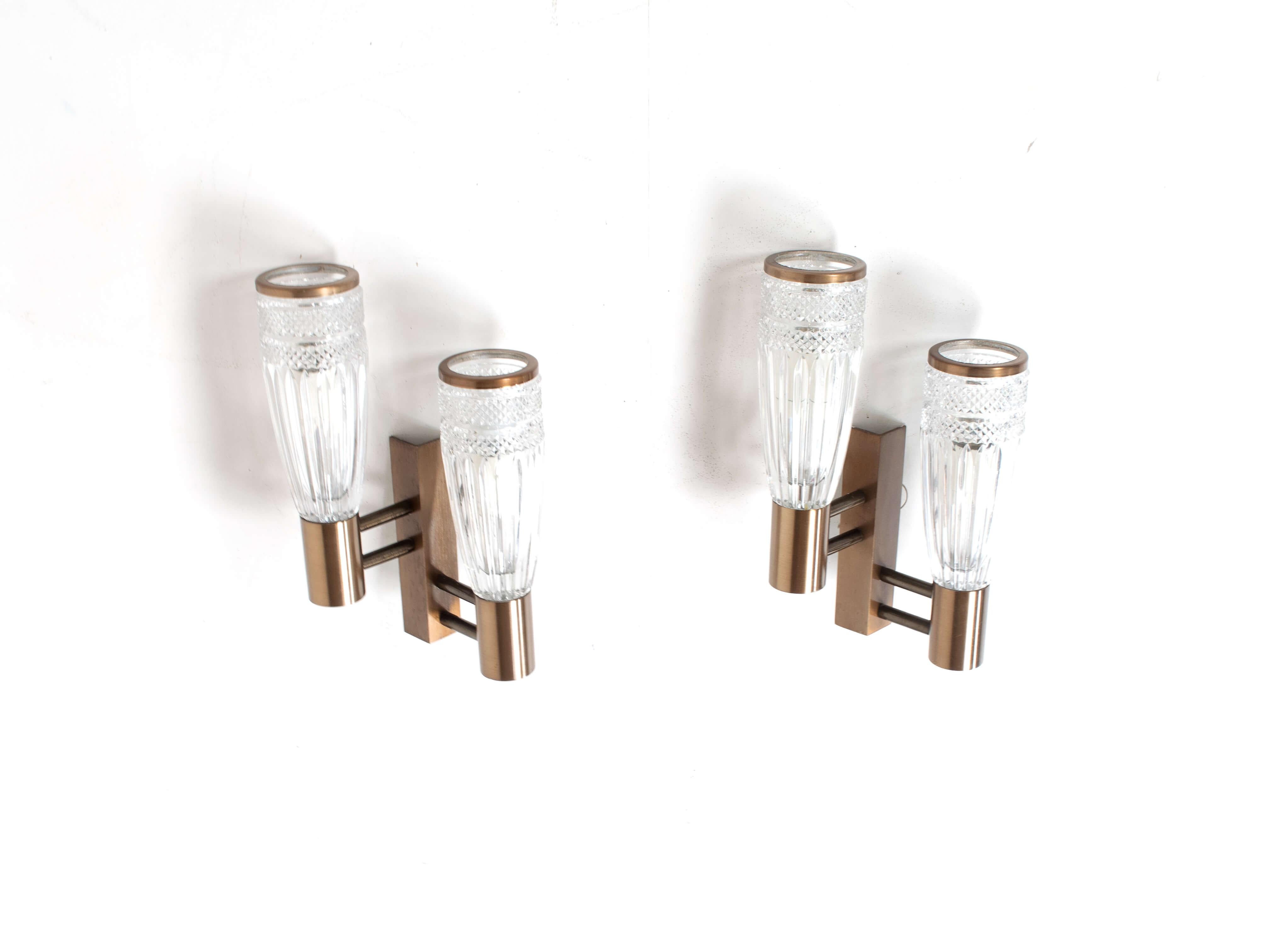 Set of three stilux wall appliques in glass, wood and metal from Italy, 1960s. These lights have an amazing design with a bronze colored base and crystal style glass. There are two items that have double lights and one that has a single light. The