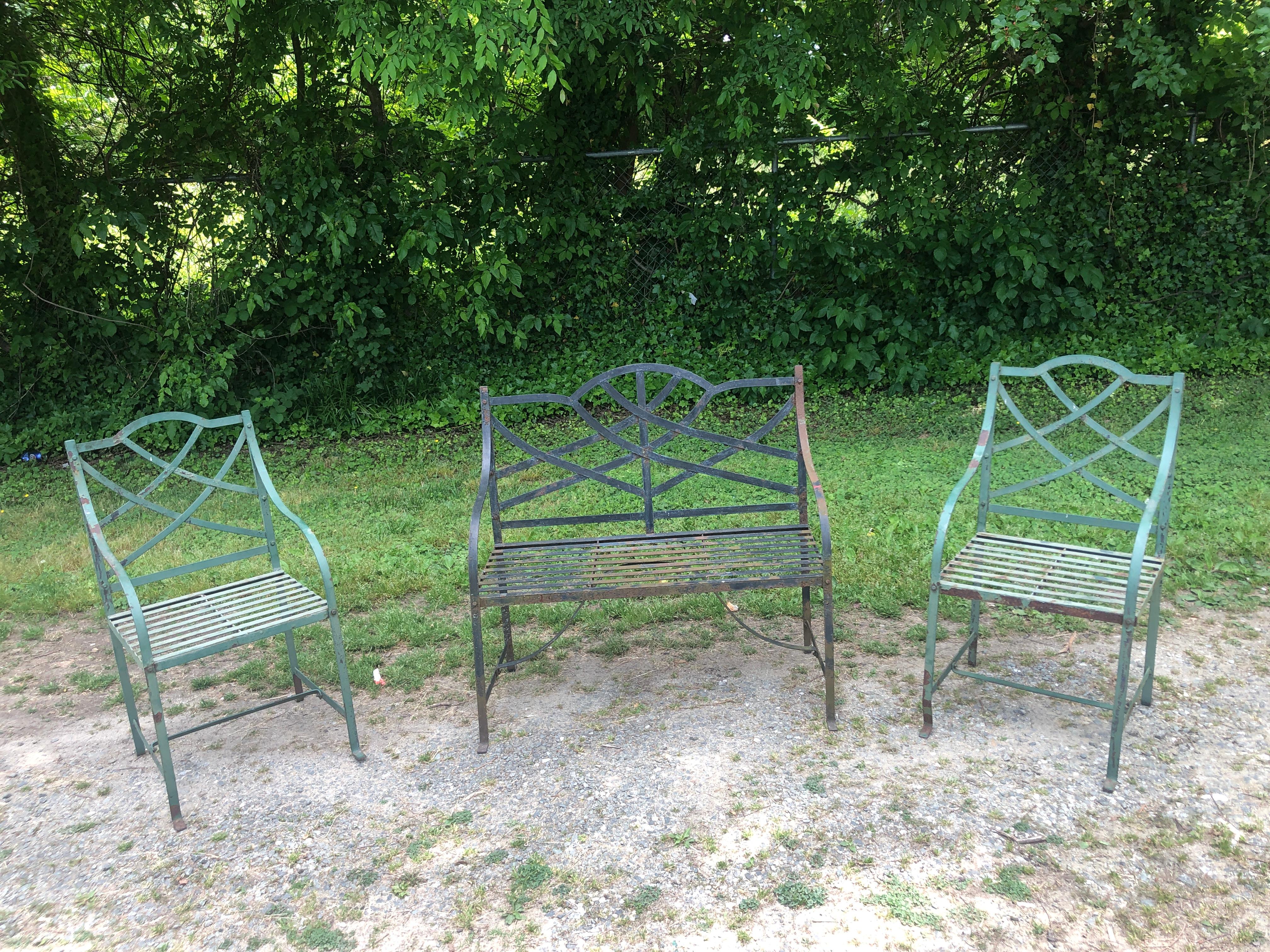 Set of Three Strap Iron Garden Suite. Set consists of small love seat and 2 armchairs. All are in old paint and show signs of rust. At your expense we can have the set sand blasted and for an additional charge. The chairs measure 20