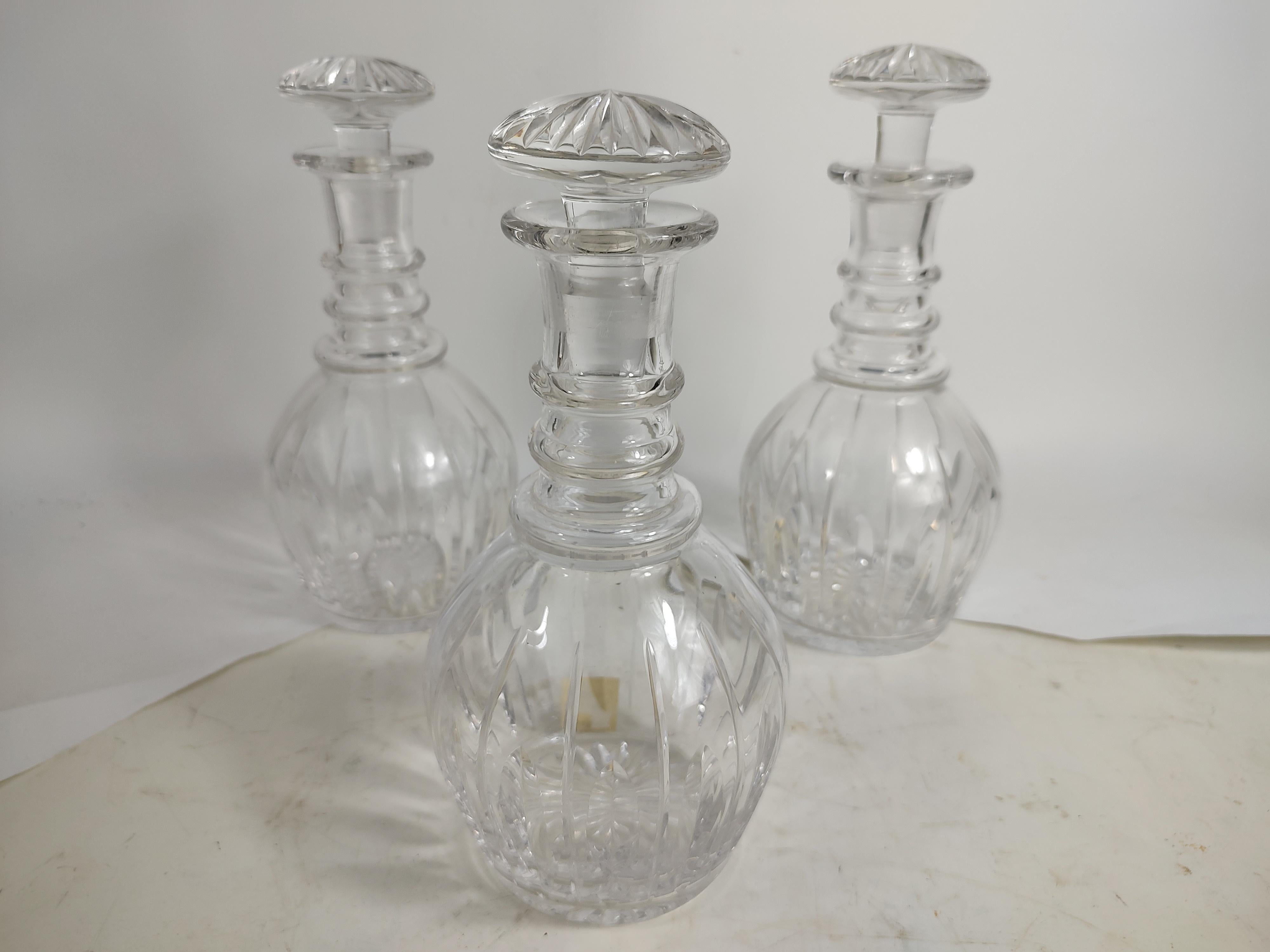 Exquisite set of 3 cut glass crystal decanter bottles by the Stuart Glass Co. of England c1940. In excellent vintage condition with minimal wear. Bottles are signed on base and two have Christie's Auction house stickers from 2007. No chips or loses.