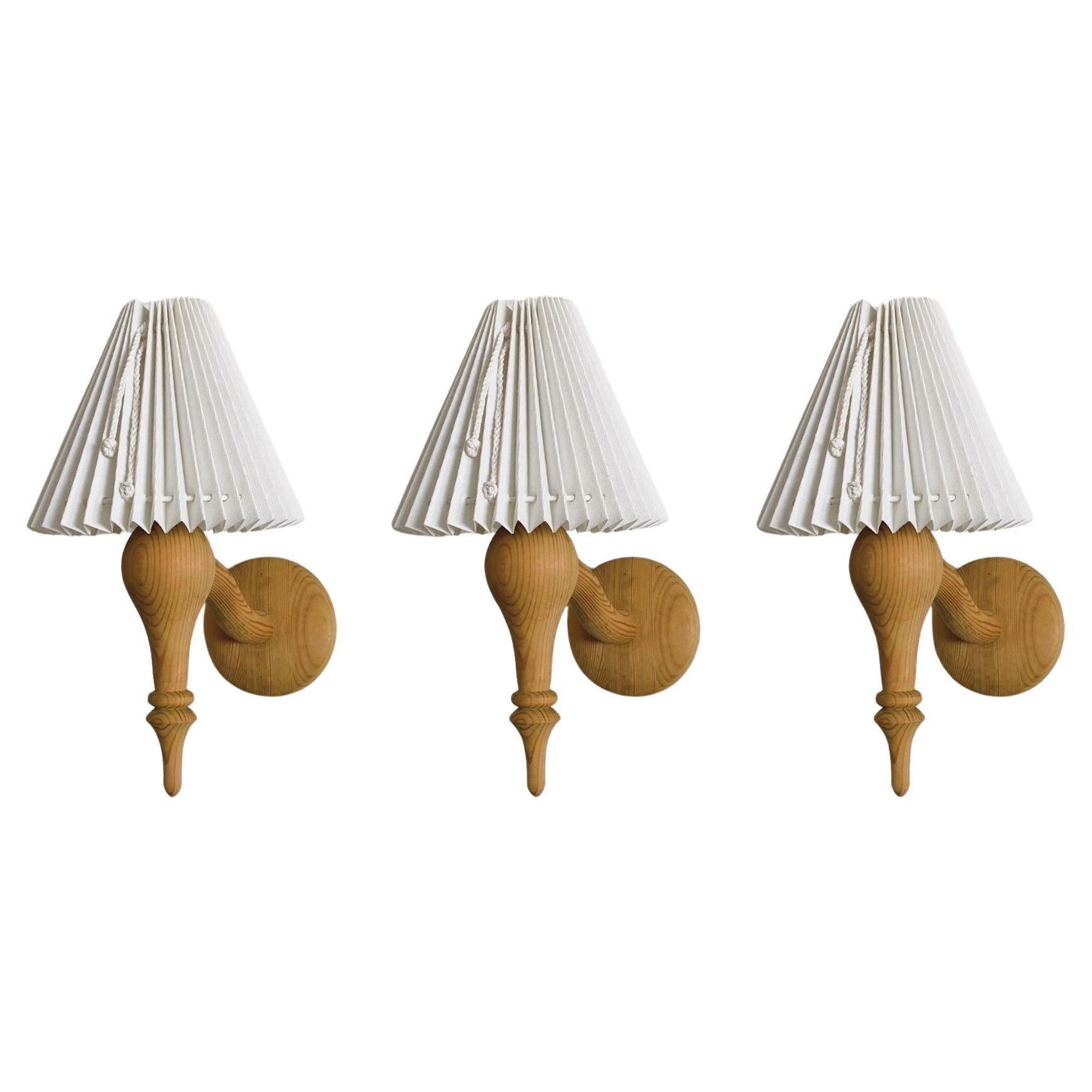 Precioso juego de tres apliques de pared de madera de pino maciza tallados a mano, diseñados y fabricados en Suecia en la década de 1960. Líneas limpias y diseño orgánico de la época moderna escandinava, bellamente talladas a mano con pantallas de
