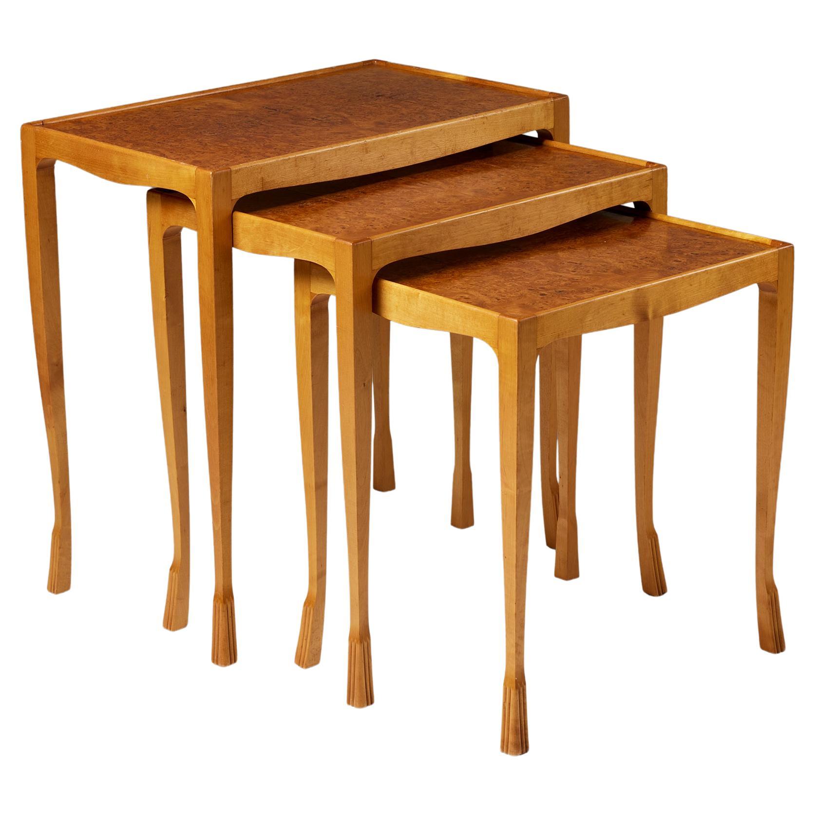 Set of three Swedish Grace nesting tables, anonymous,
Sweden, 1940s.

Birch and root veneer.

Signed.

Small:
H: 46 cm 
W: 42 cm
D: 33 cm

Medium:
H: 51 cm
W: 47.5 cm
D: 33 cm

Large:
H: 56 cm
W: 54 cm
D: 33 cm

One of the briefest, yet among the