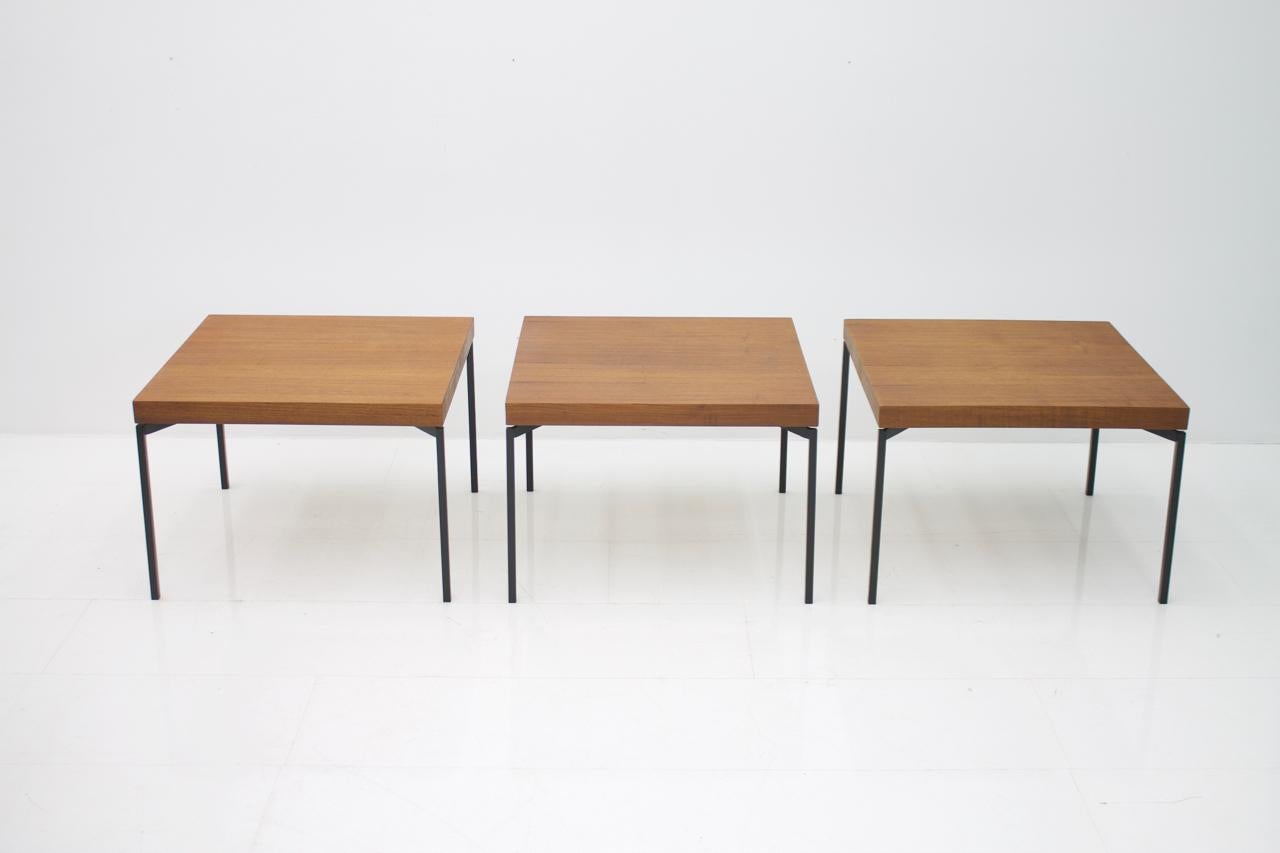 Set of three teak wood side or end tables with solid lacquered metal legs. Attributed to Herbert Hirche, Germany, 1950s.
Price is per item,
Very good restored condition.

We dismantle the tables for shipping.