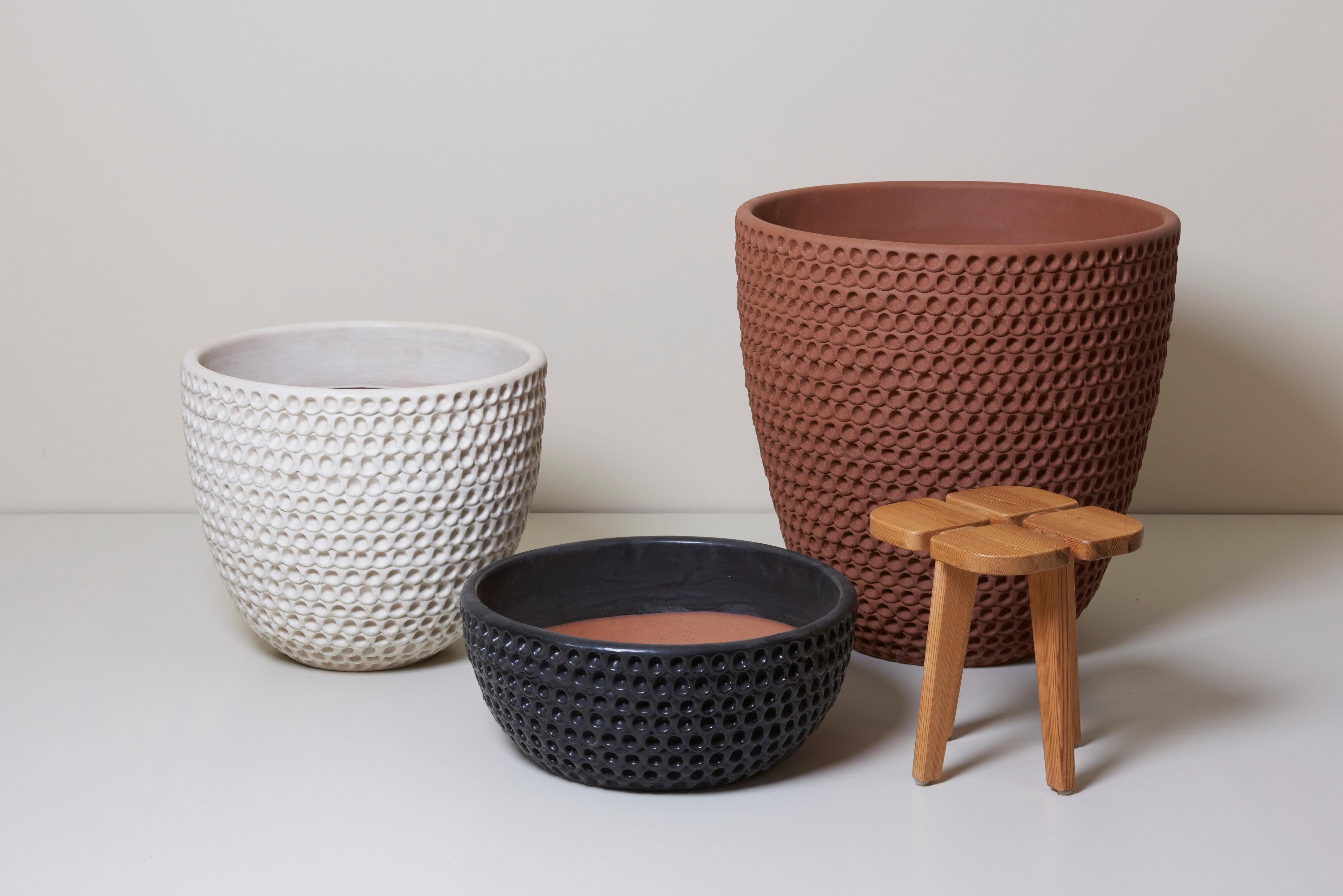 Set of a large brown, a medium white and a small black thumbpot by Fresno, California Artist Stan Bitters. The planters are hand-built with thumbprint design. The hand-built, organic, earthy pots exist comfortable in a garden area. The pots are made