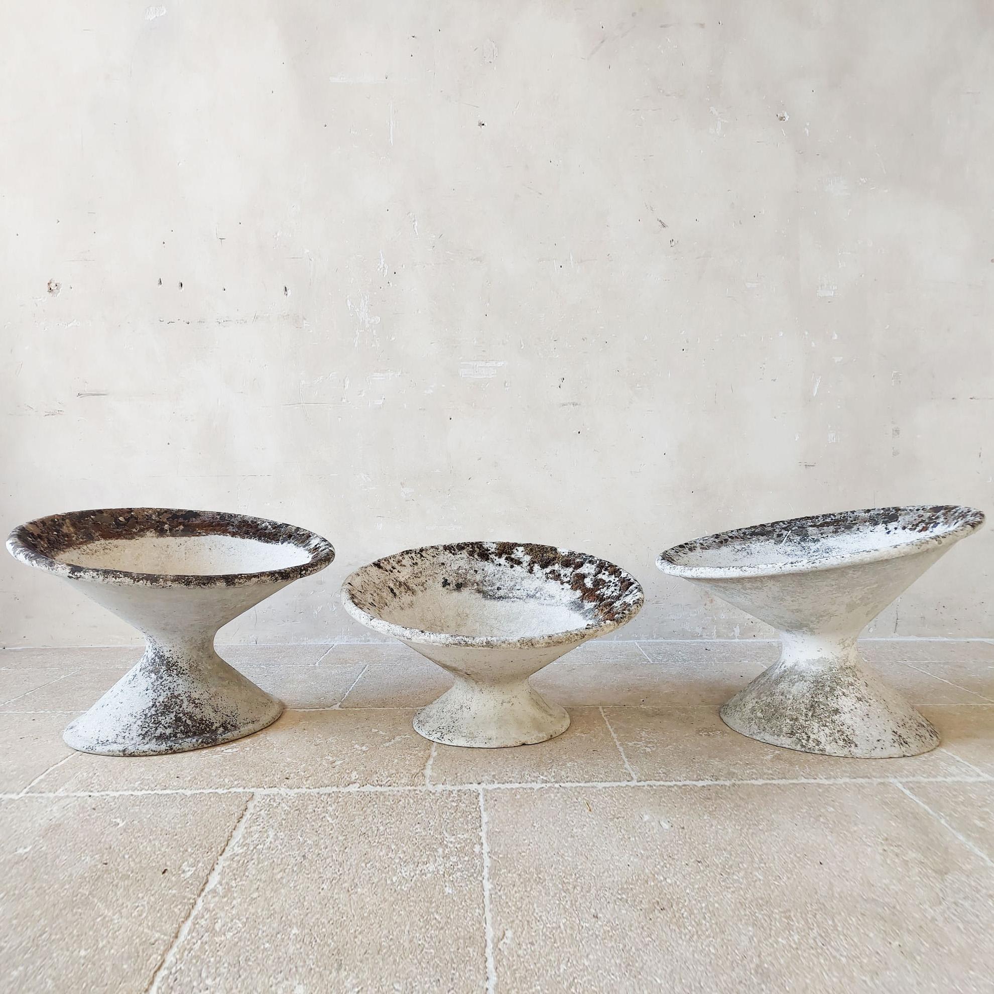 Price for the set of 3!
Set of three tilted concrete planters by the Swiss architect Willy Guhl. Manufactured by Eternit AG, who produced all of Guhl’s designs. Made from fiber cement, the planters are lightweight and durable in all climates. These