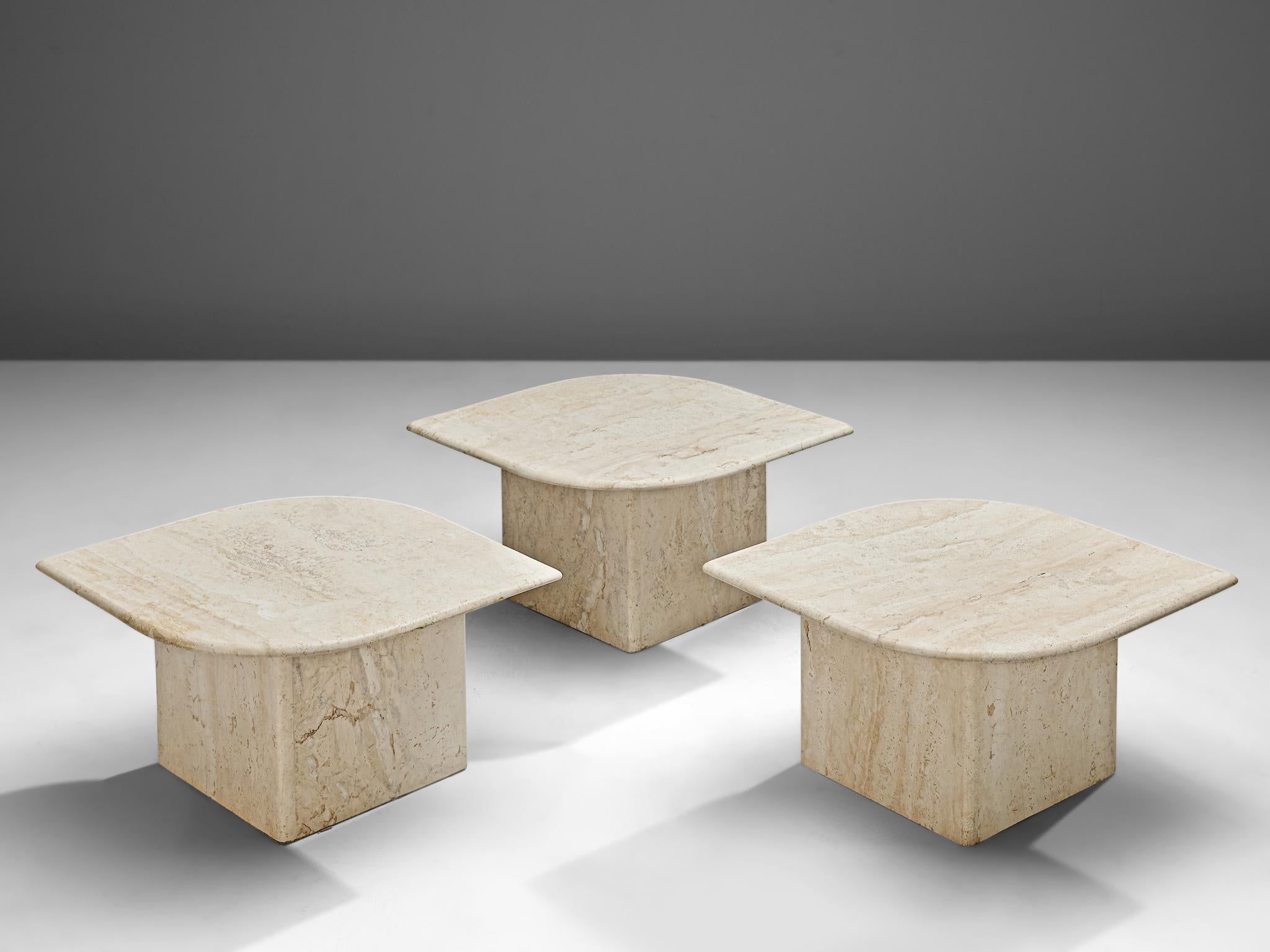 Set of three coffee tables, travertine, Italy, 1970s.

This set of three coffee tables each feature a leaf-shaped travertine tabletop and an L-shaped base. The aesthetics are archetypical for postmodern design, referencing architectural shapes and