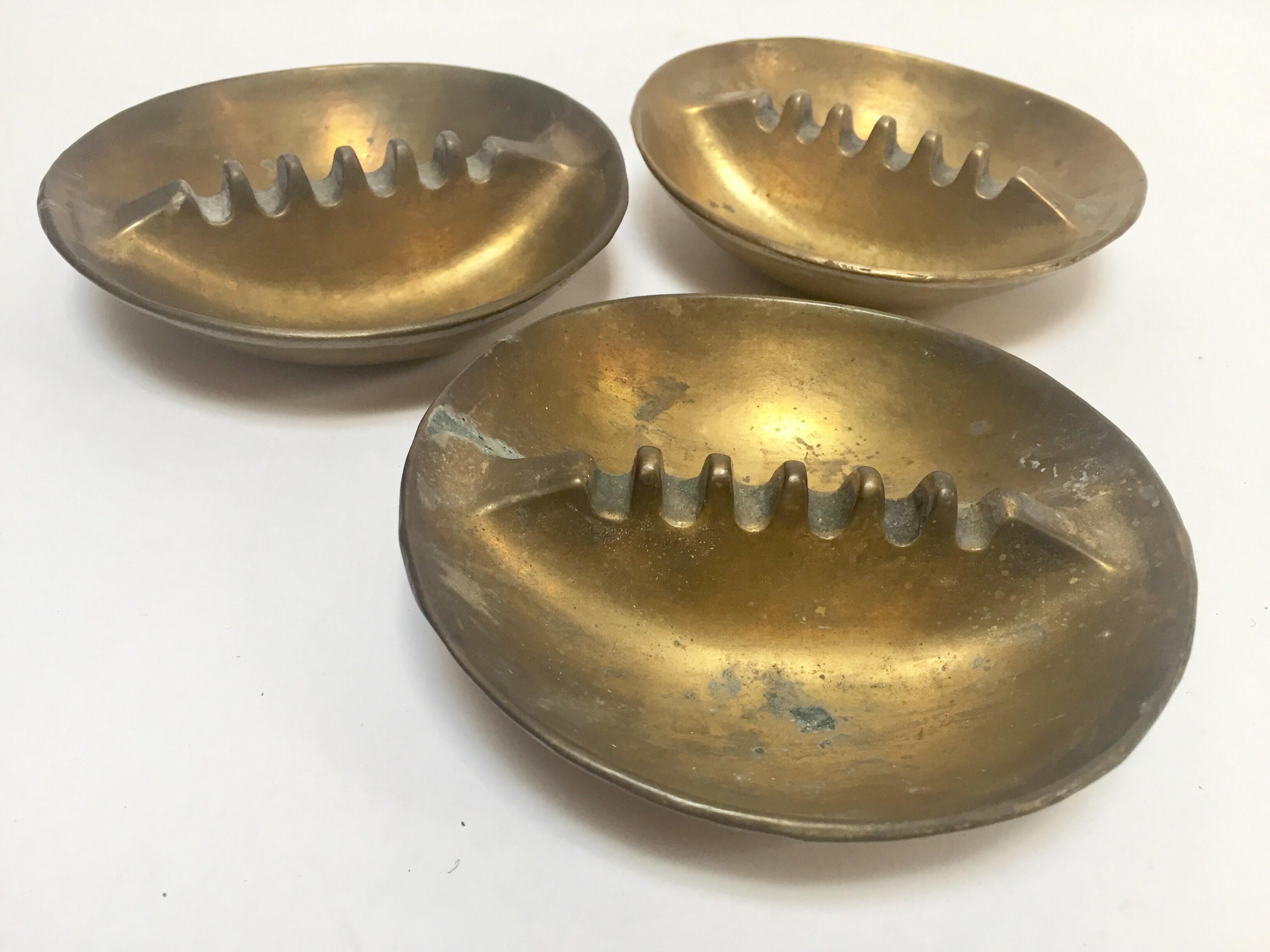 Set of three vintage 1960 solid brass ashtrays.
Handmade cast brass with beautiful bronze patina finish. 1960 solid brass ashtray, brass sculptures, vide poche, decorative object.
A vintage midcentury set of three stackable ashtrays with textured